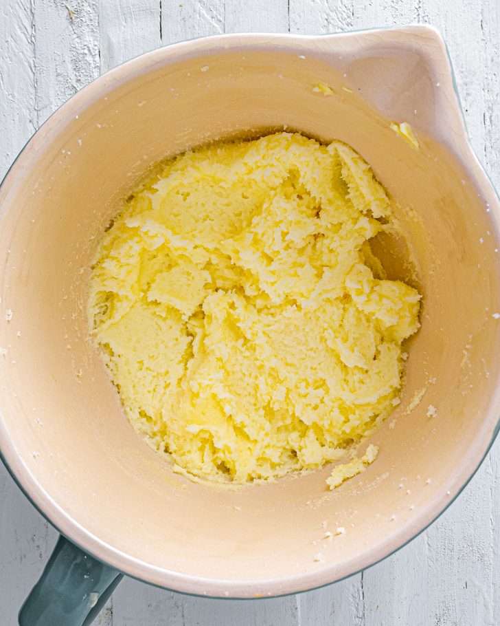 Place the sugar and butter into a mixing bowl, and blend until smooth. 