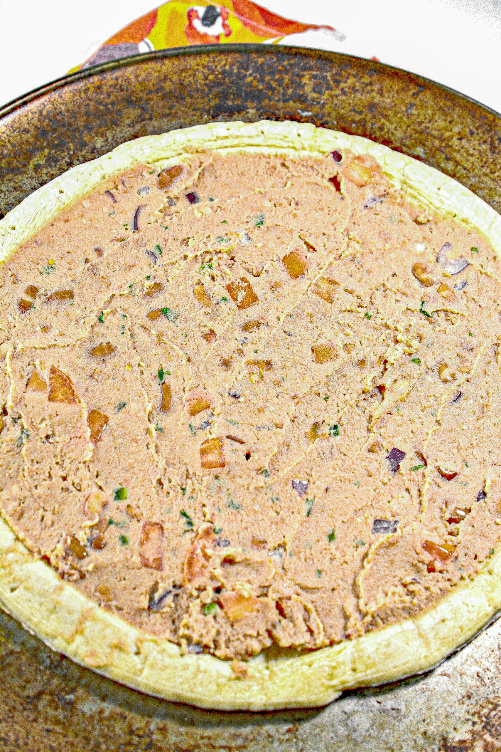 Spread the bean mixture out in an even layer over the prepared pizza crust.