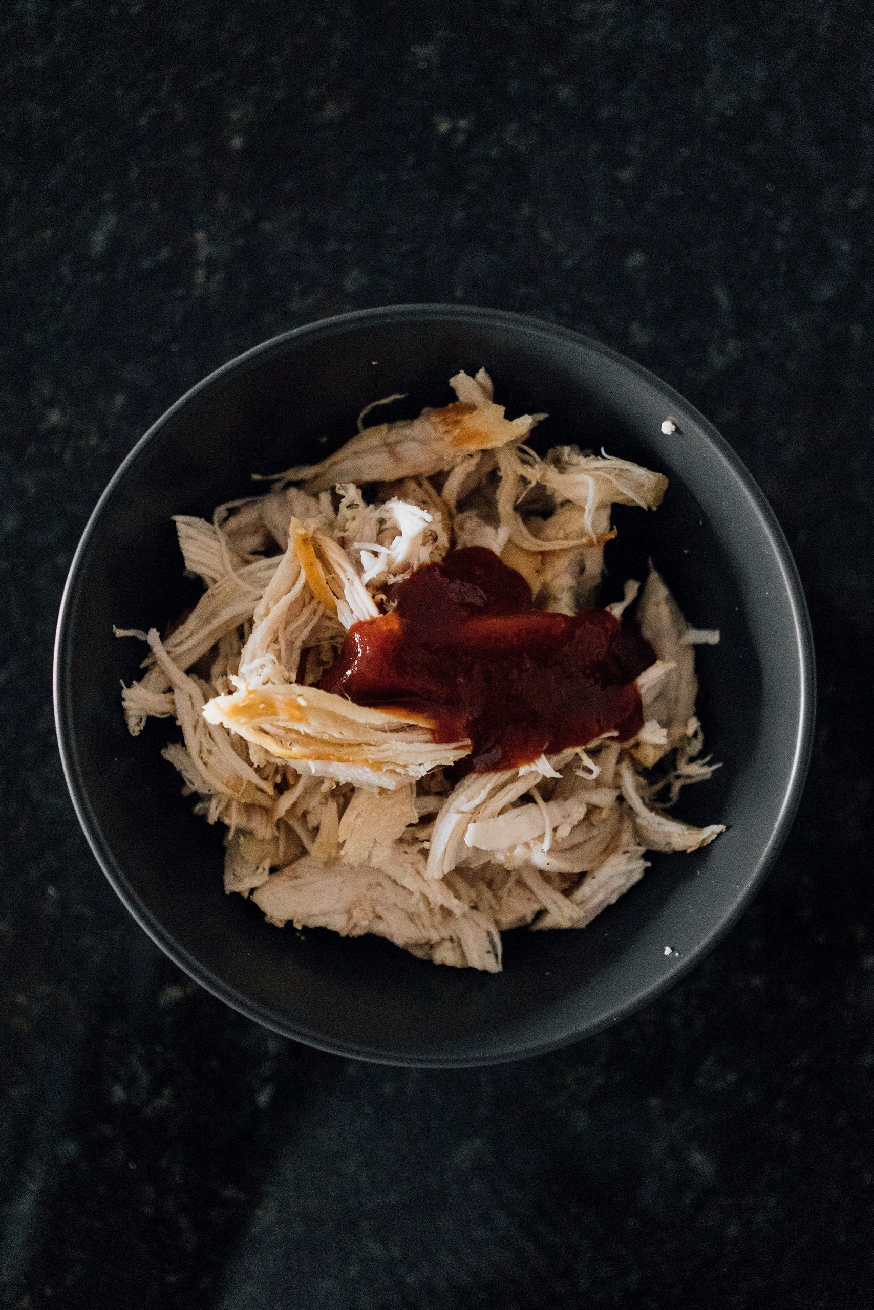 Mix the shredded chicken with remaining 2 tablespoons of BBQ sauce and 1 teaspoon of honey. Scatter on top of bases.
