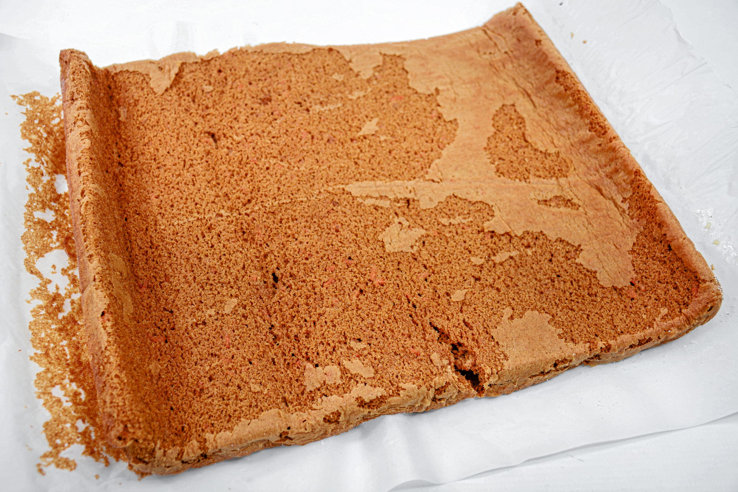 Slowly unroll the cake, carefully peel off the parchment paper.