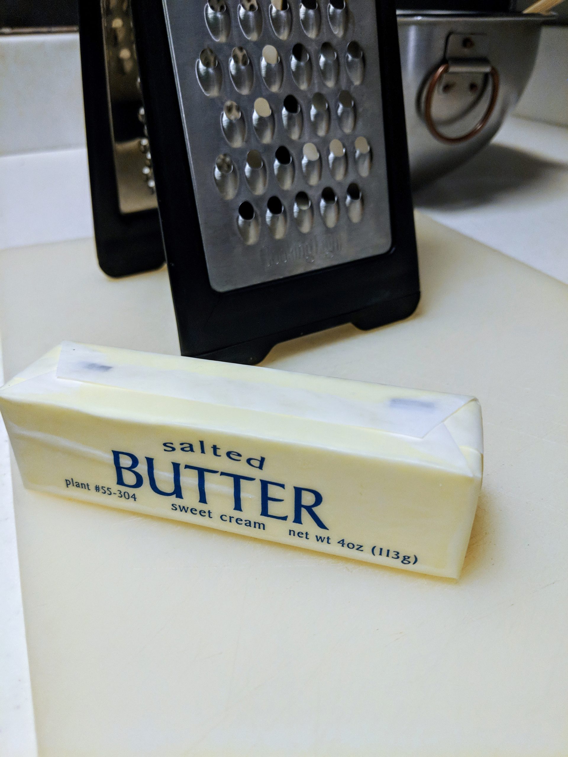 Remove your chilled butter from the freezer and dice it into small pieces. You can use a knife and cutting board to chop your butter into little cubes