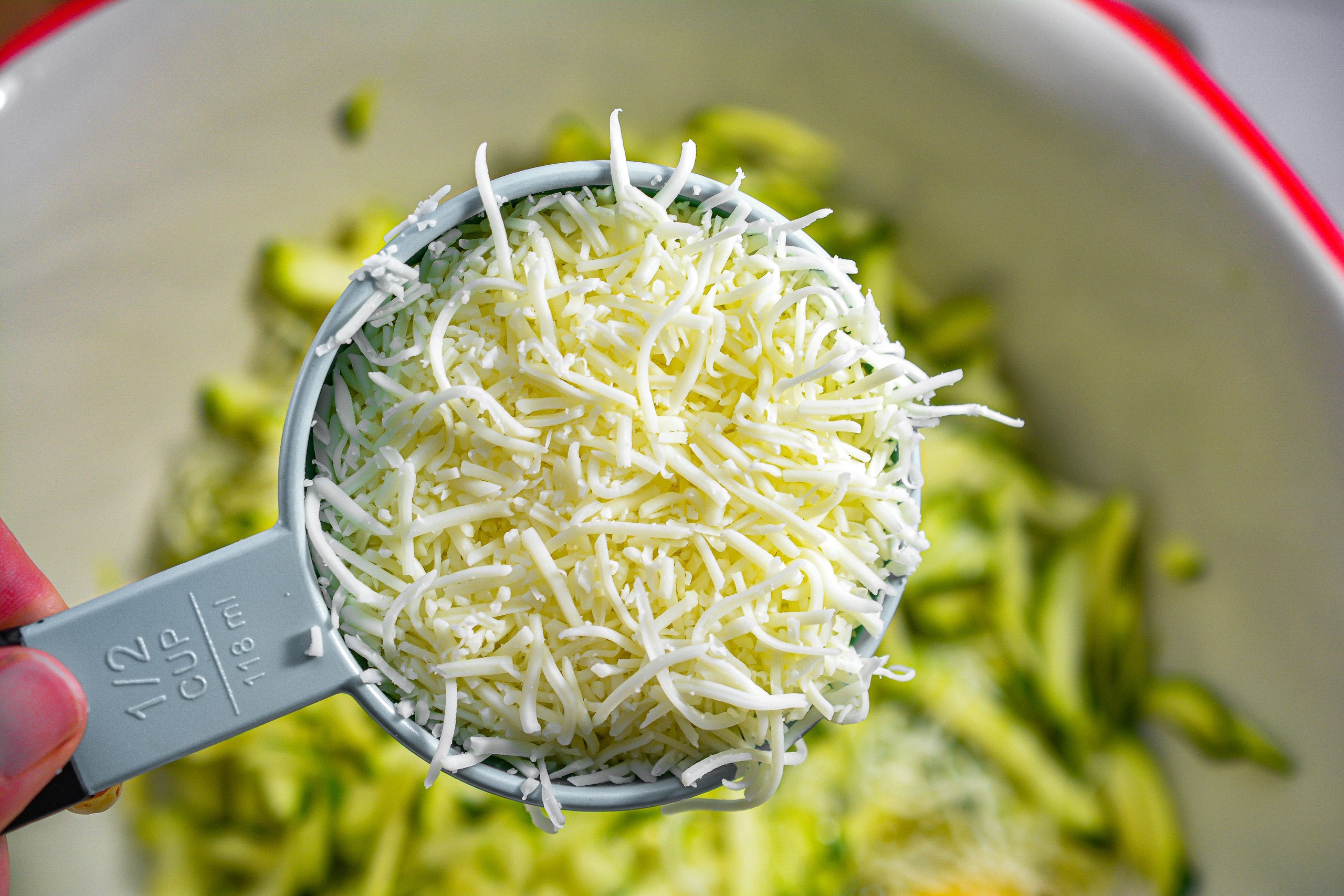 Salt and pepper to taste and ½ cup of the Mozzarella cheese into the bowl with the zucchini. Mix to combine well. 
