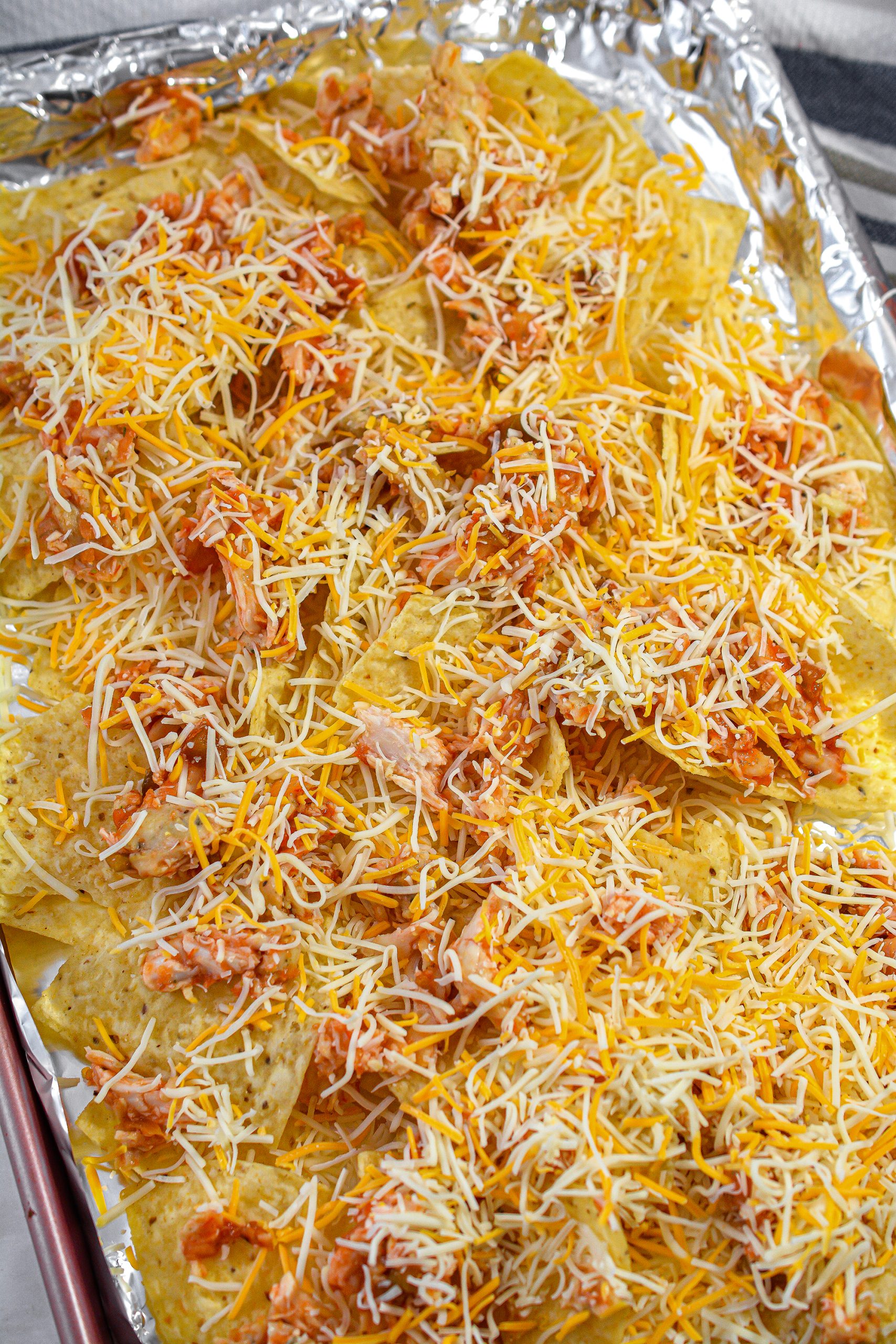 Layer half of the chicken on top of the chips and then sprinkle with half of the cheese.