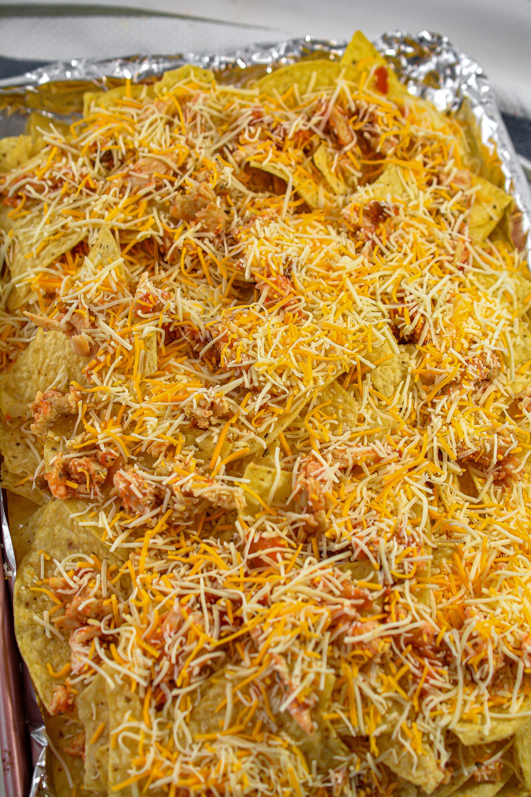 Add another layer of chips on top of the first one, and then top with the remaining chicken and cheese as well as the black beans.