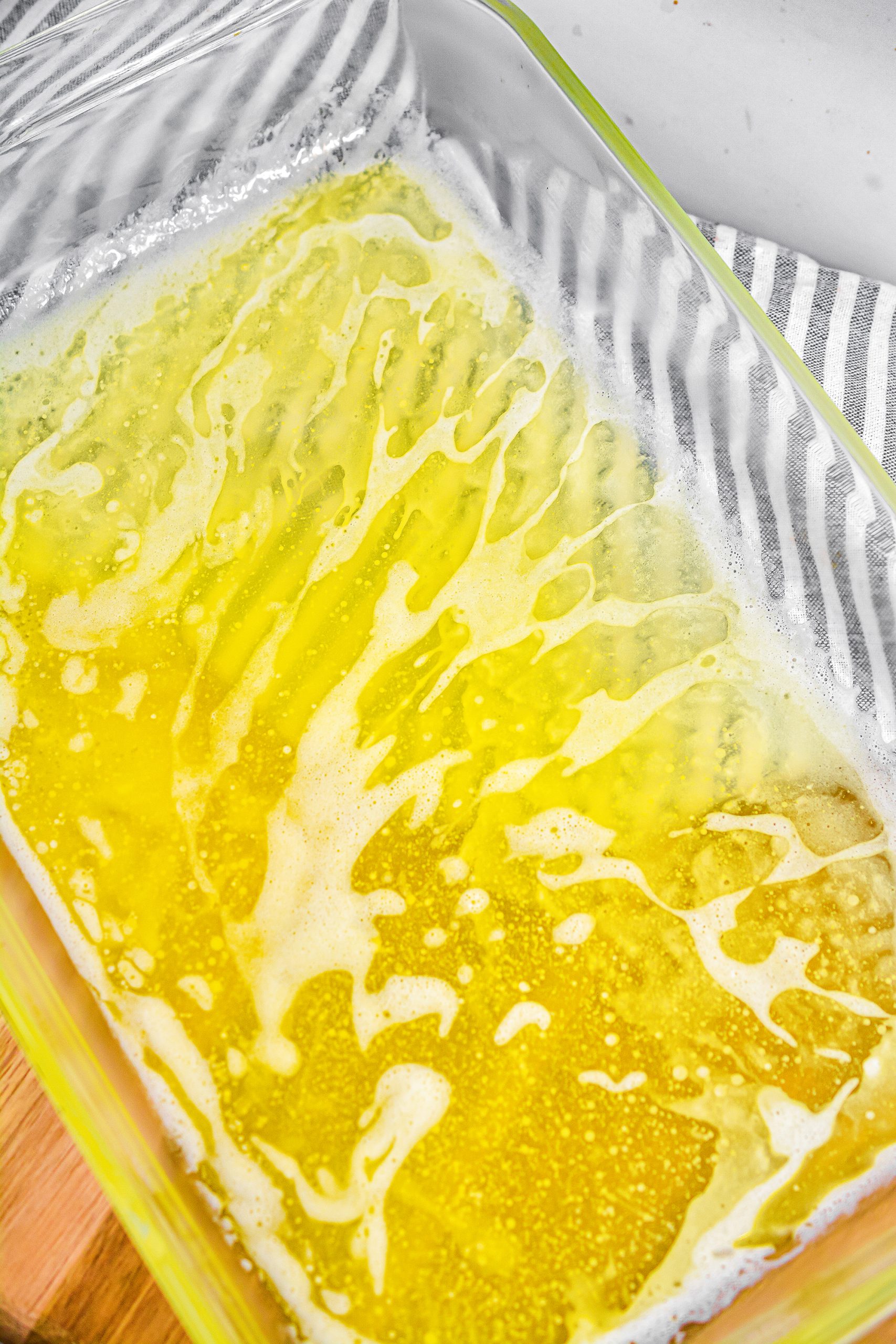 Add the melted butter to a 9x13 baking dish. 