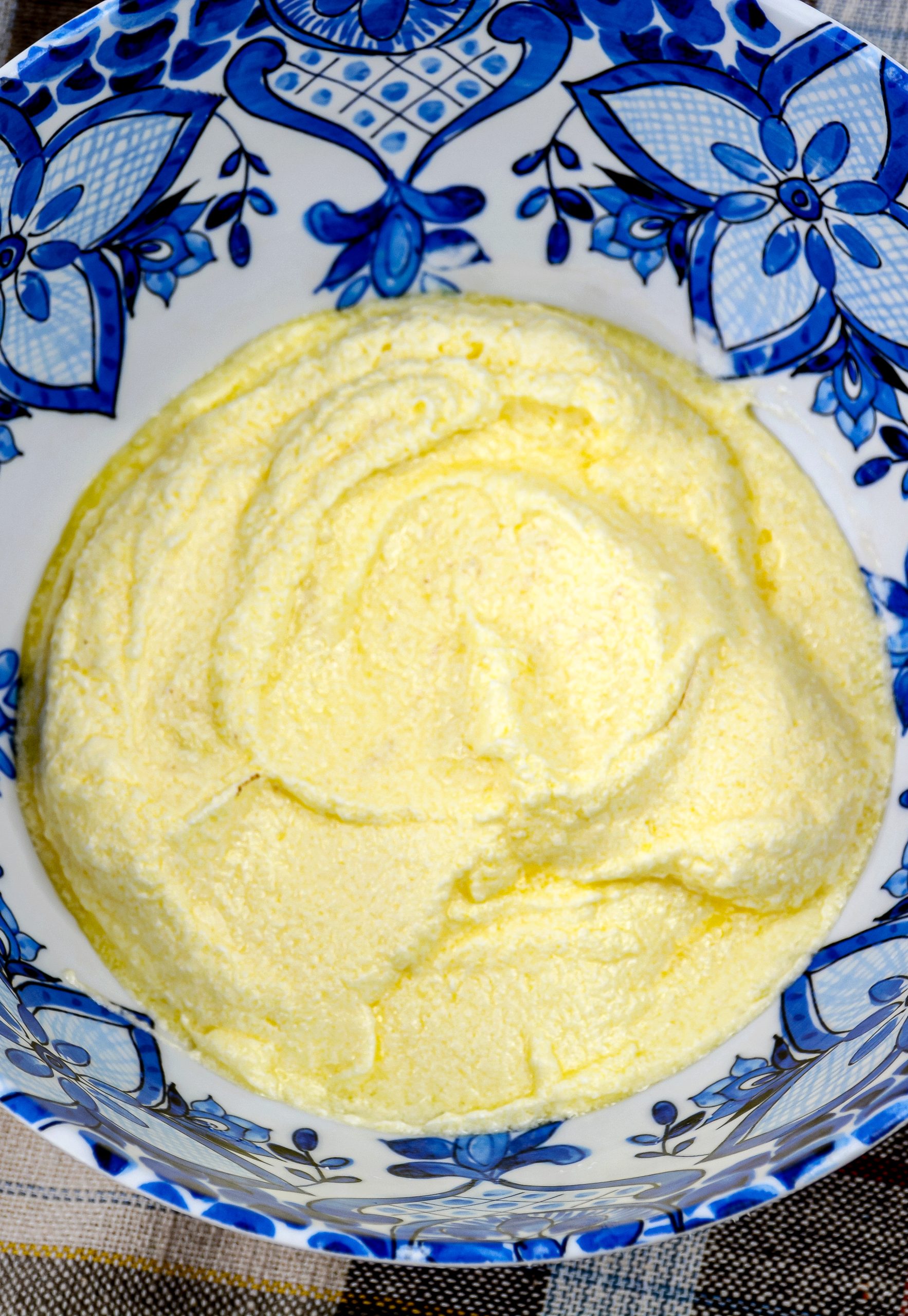 Add melted butter in a mixing bowl, add sugar and using an electric mixer cream the butter and sugar.