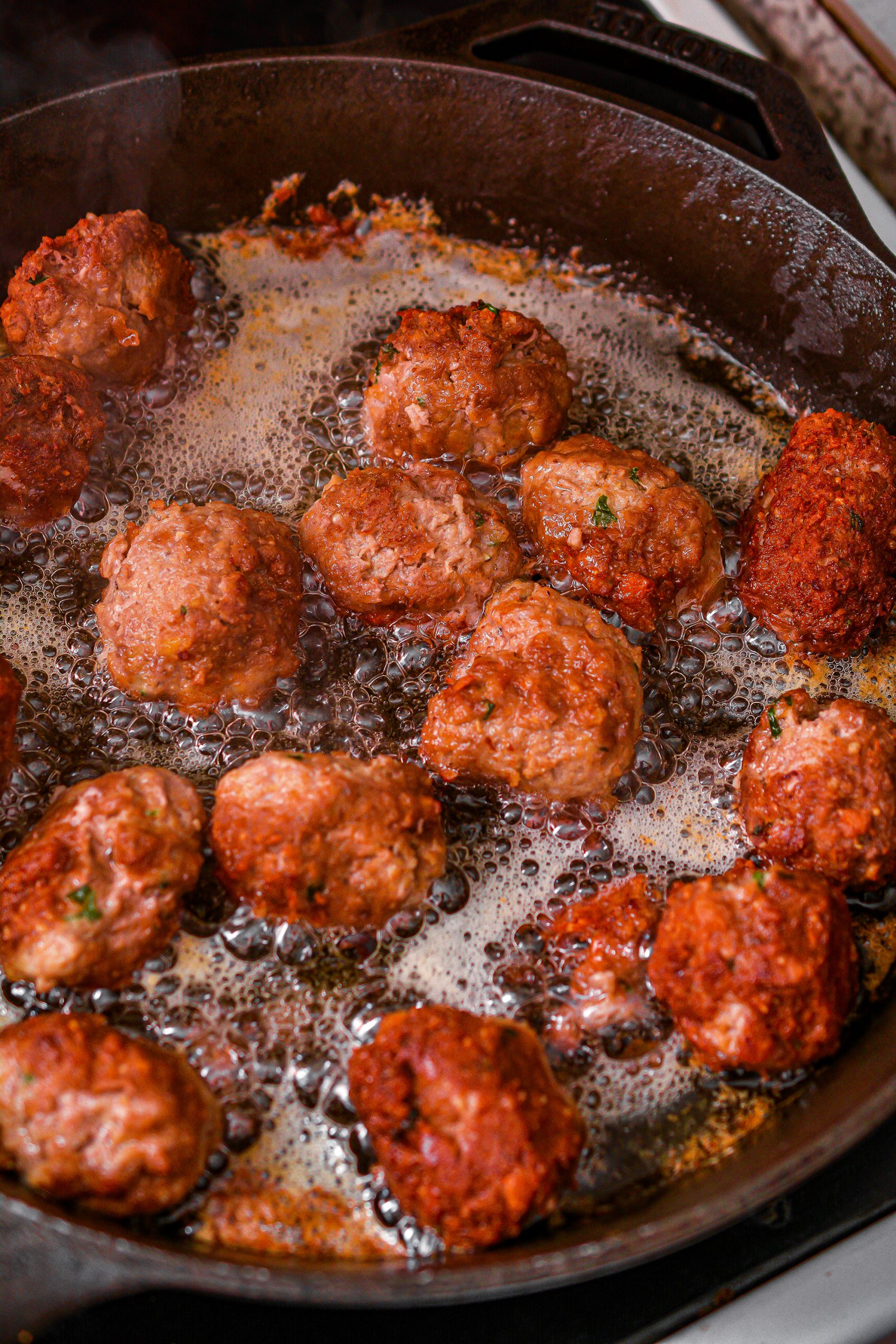 Add the meatballs to the heated oil, frying on all sides until completely cooked through.