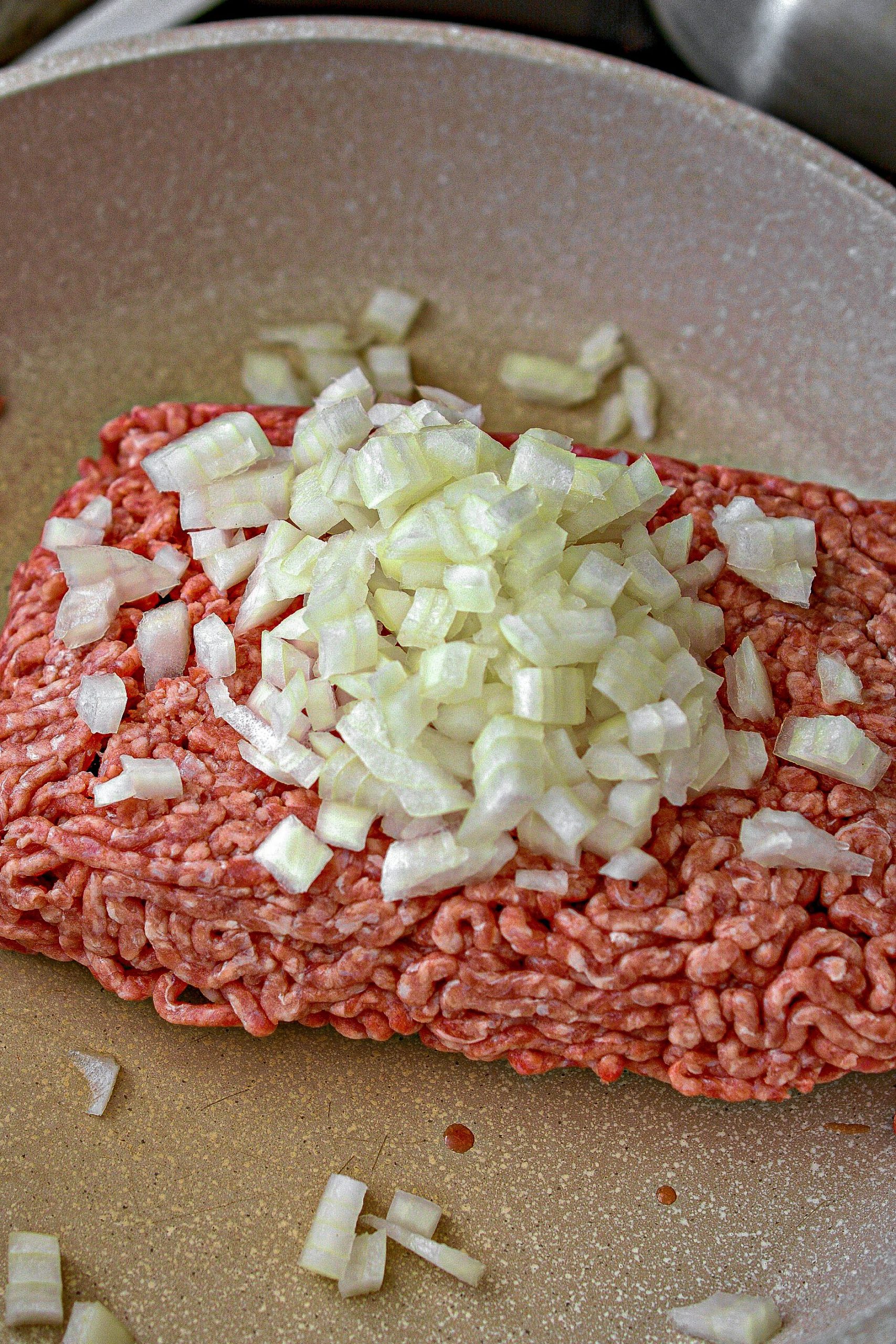 Place the ground beef and onion into a large skillet over medium-high heat on the stove. 