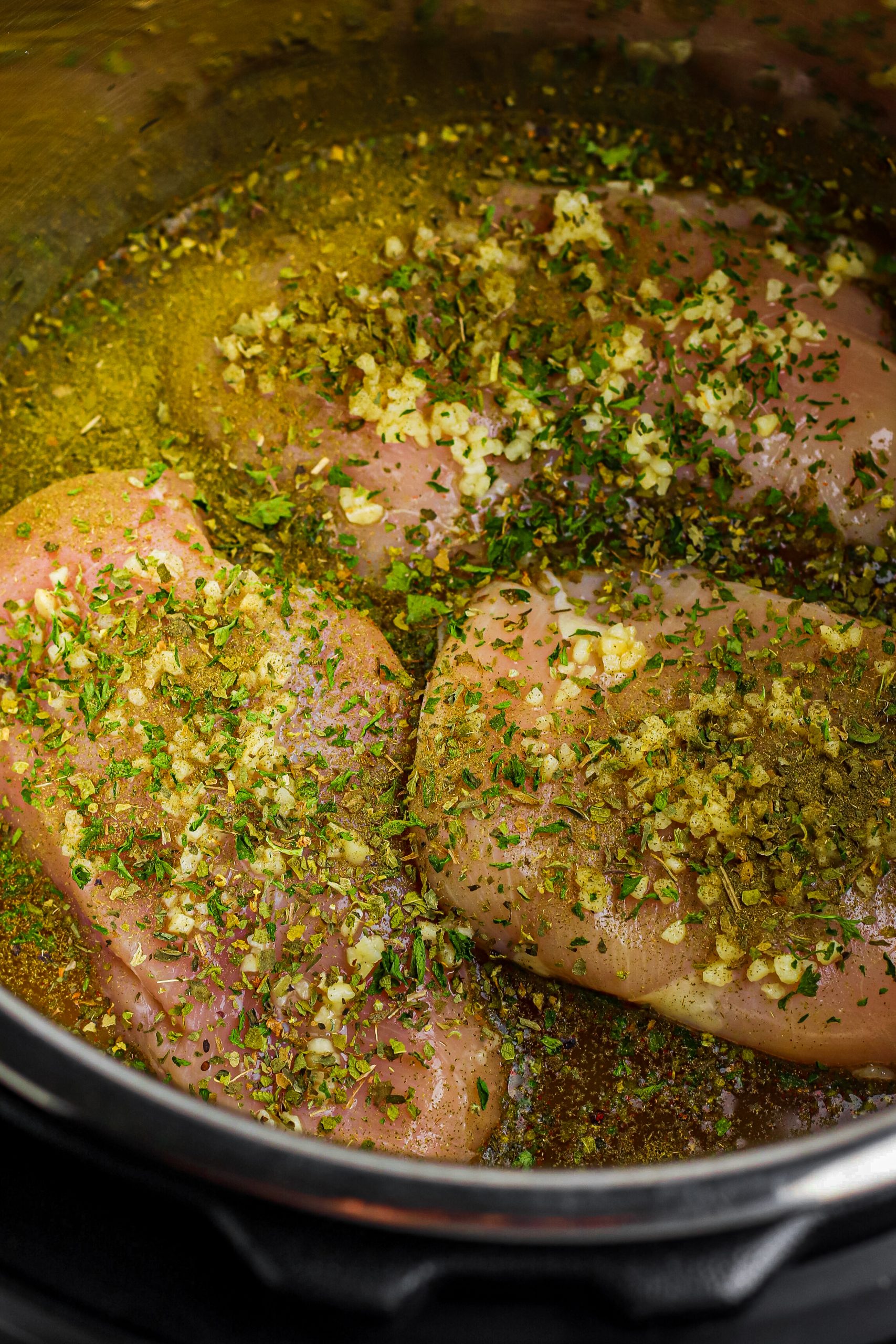 Place the chicken breasts on top of the rice. Season with minced garlic, remaining Italian seasoning, and parsley.