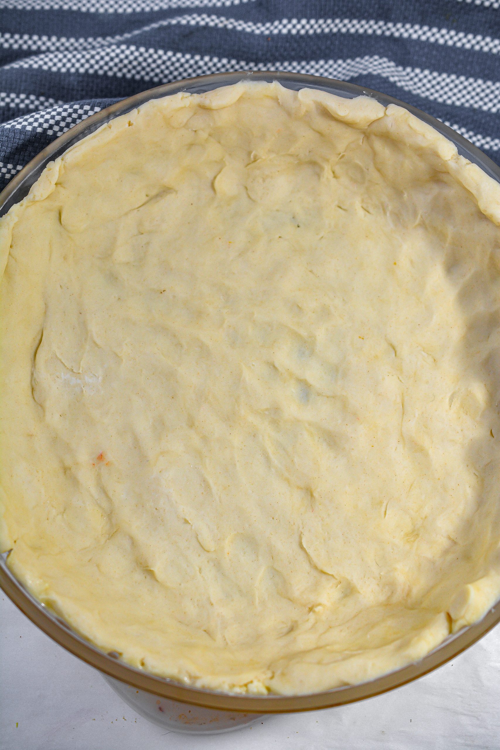 Remove the chilled dough from the fridge and press into a well greased 9 inch pie dish.