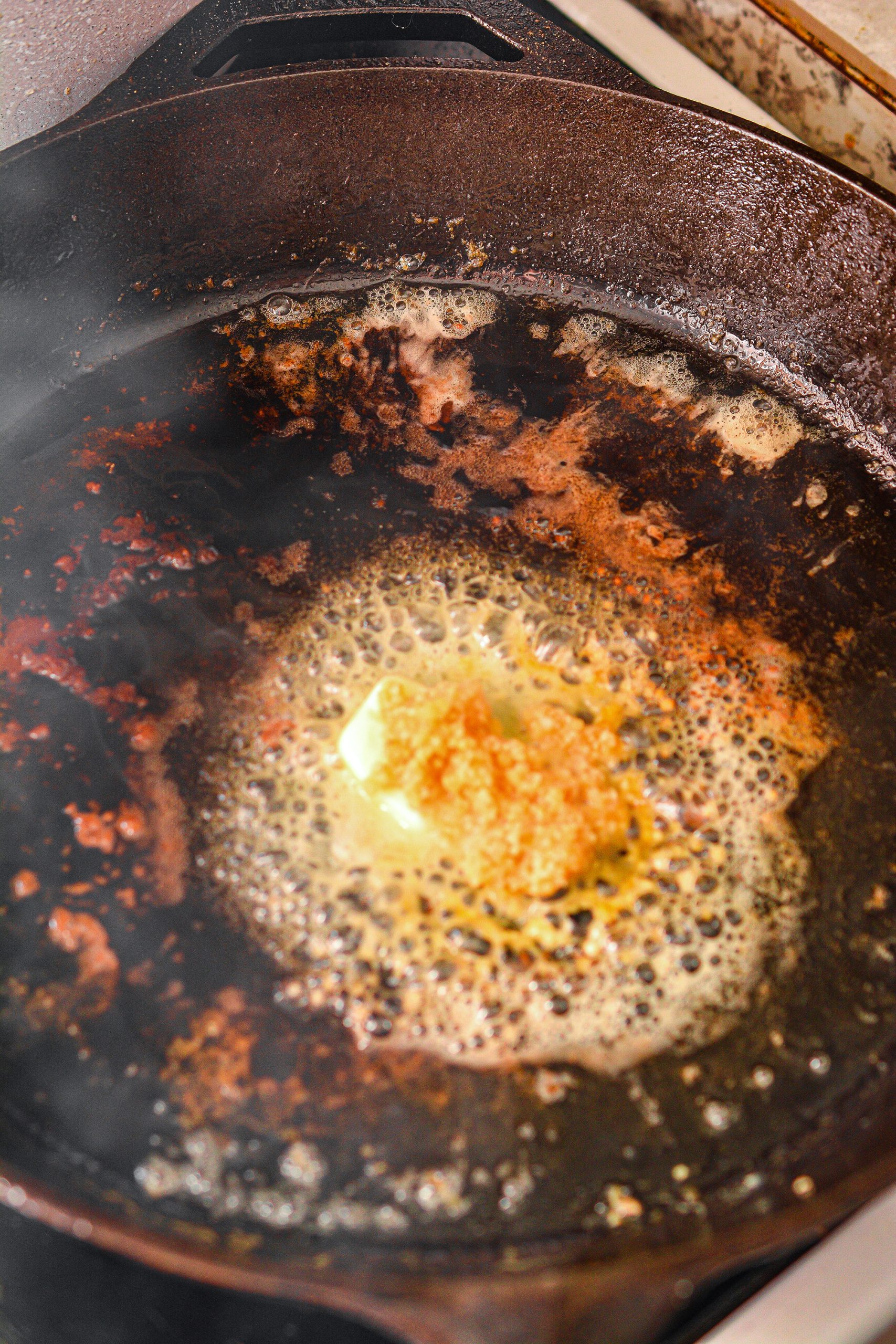 Remove the extra oil and grease from the skillet and return it to the stove over medium heat.