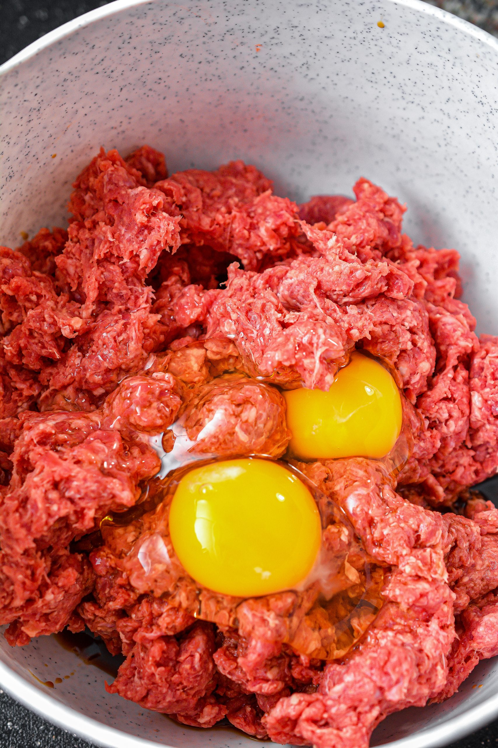 In a bowl, knead together the ground beef, eggs, onions and peppers, breadcrumbs, minced garlic, onion powder, worcestershire sauce and salt and pepper to taste until well combined.