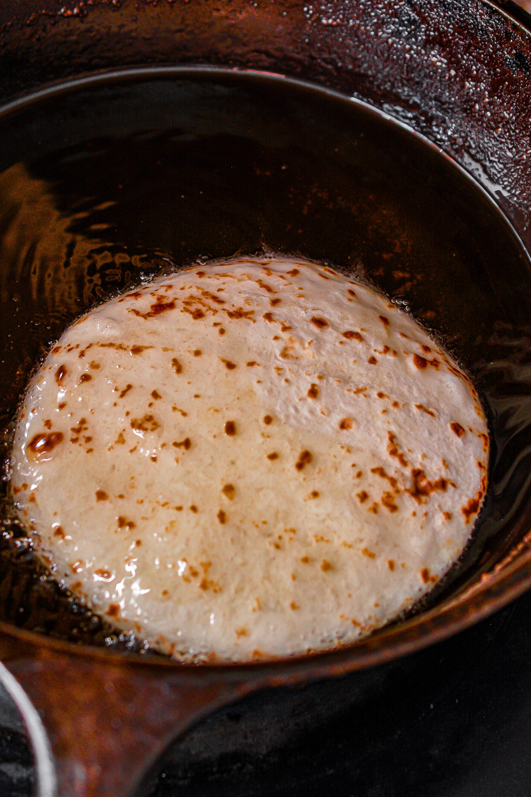 Fry the tortillas for 1 minute on each side until lightly browned and slightly crispy. 