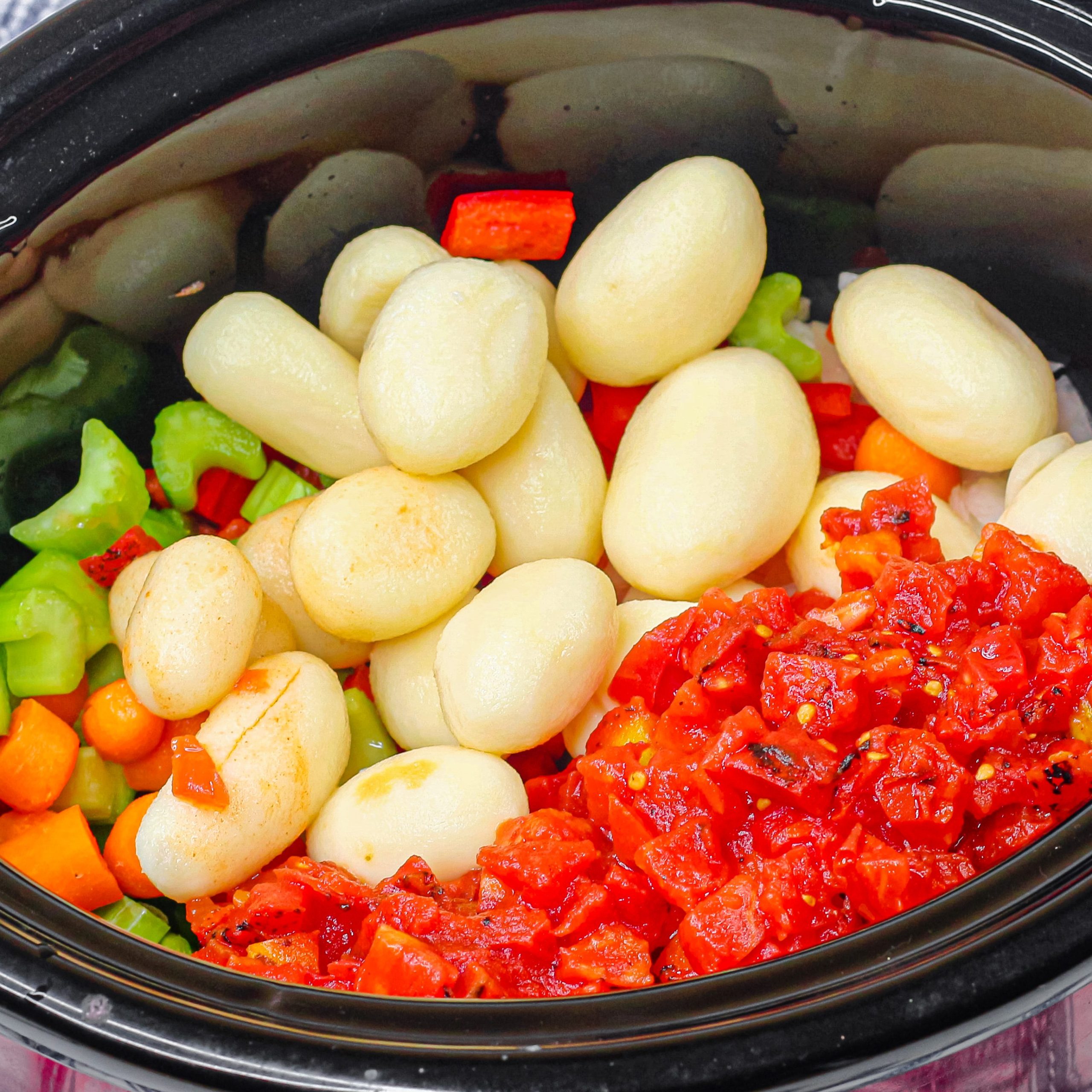 Add the chicken, vegetables, tomatoes, about 8 cups of water, parsley, minced garlic, salt, and pepper in a crockpot.