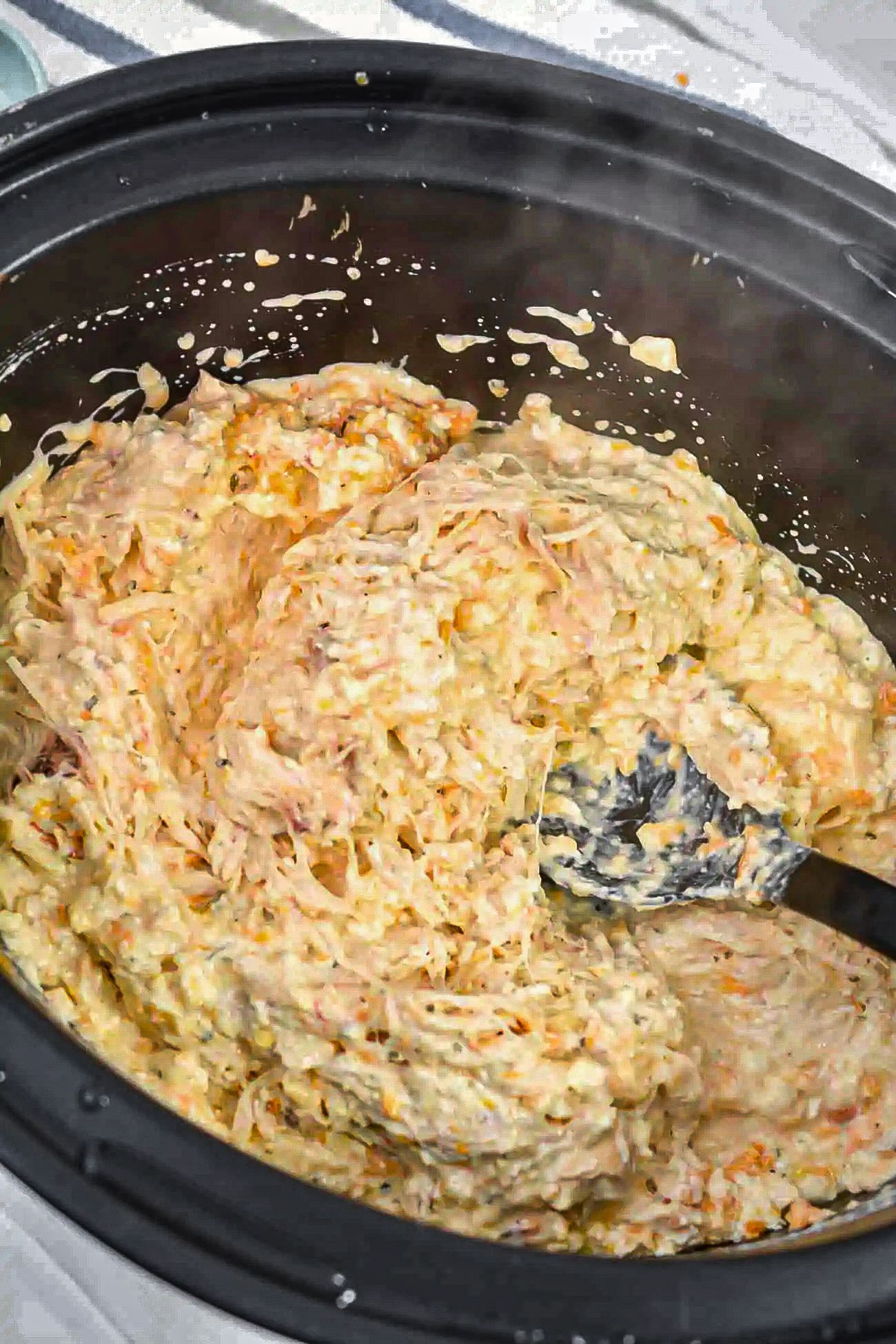 Remove the lid, shred the chicken, and stir to combine the ingredients in the slow cooker well.