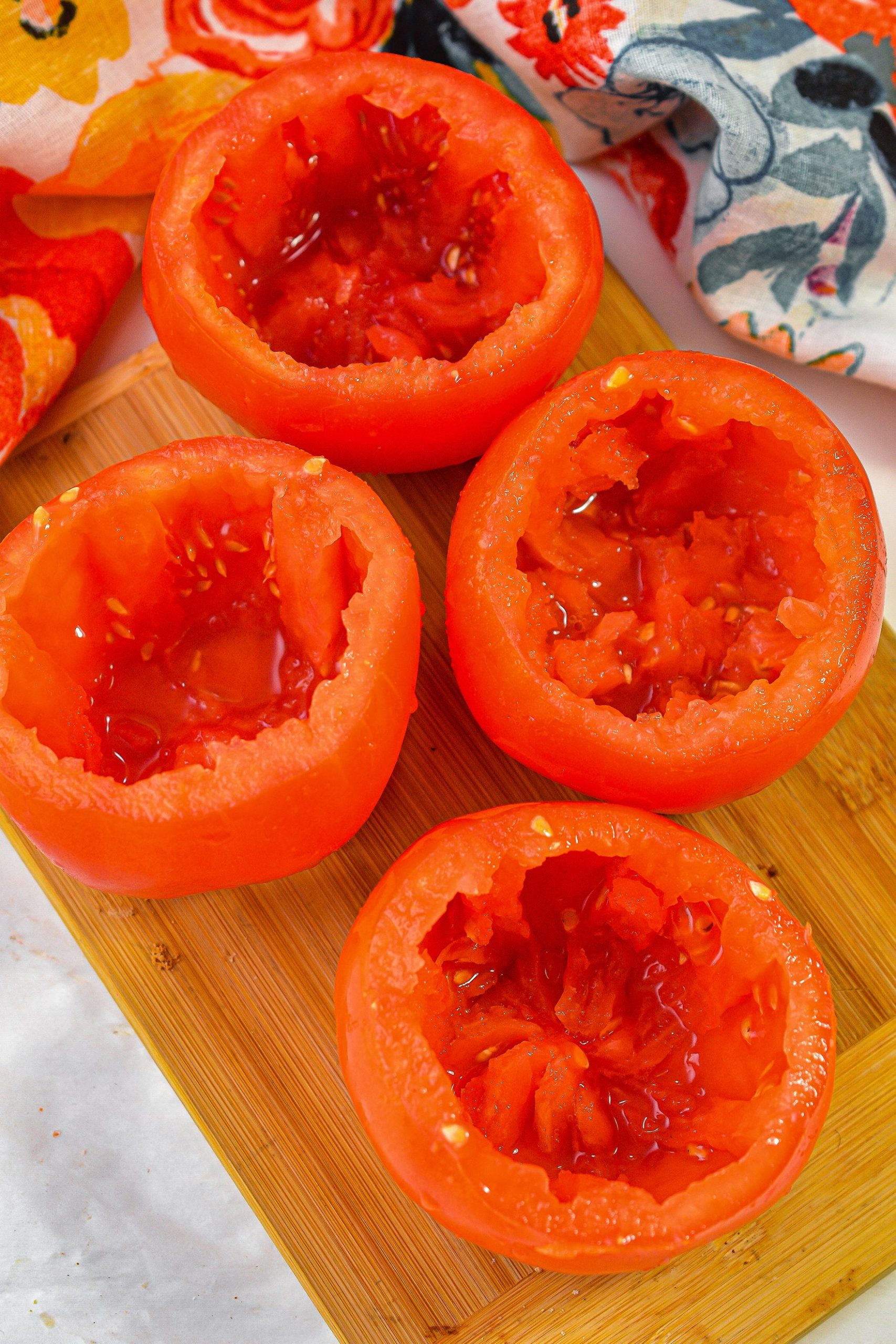 Slice the top of the tomatoes off, remove the center of the tomato and spoon out the inside.