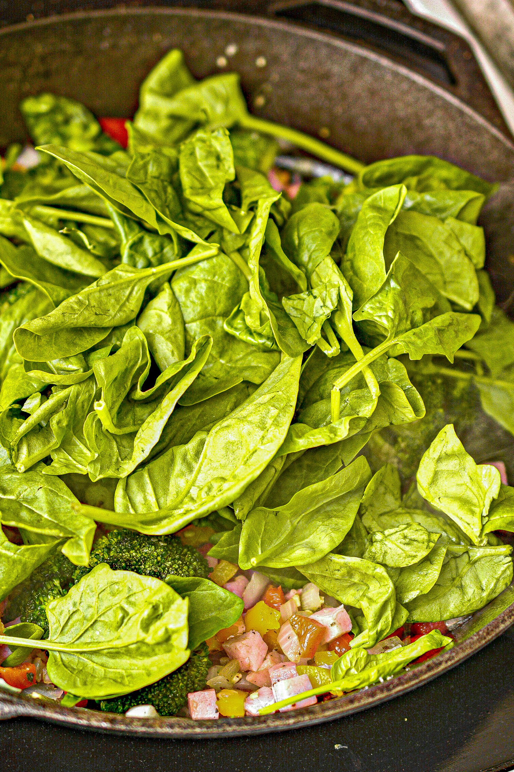 Place the spinach into the skillet, and cook until it is just wilted.