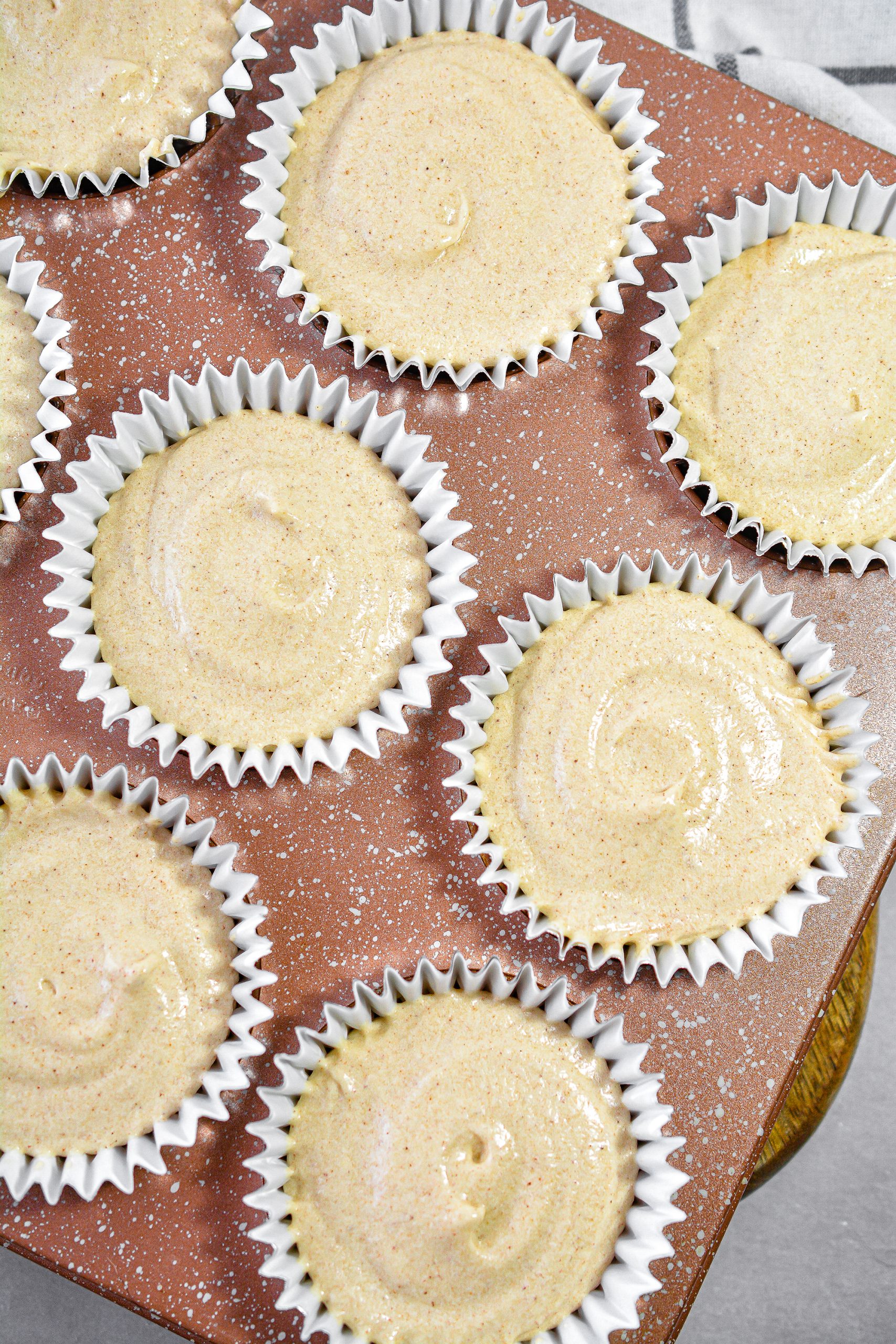 Fill 12 sections of a muffin tin with cupcake liners, and fill each liner ⅔ of the way full of the batter.