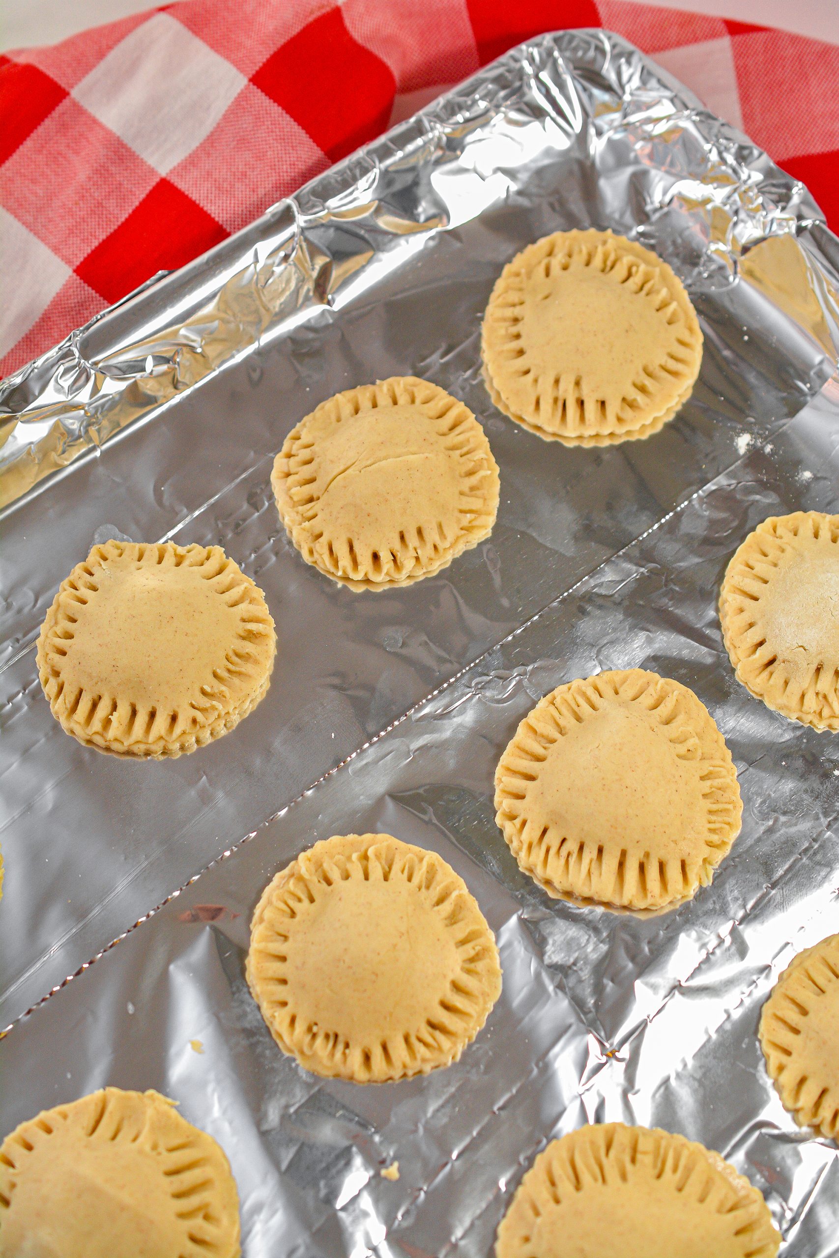 Cover the filling with another circle of dough on top, and use the tines of a form to crimp the edges of each filled cookie closed.