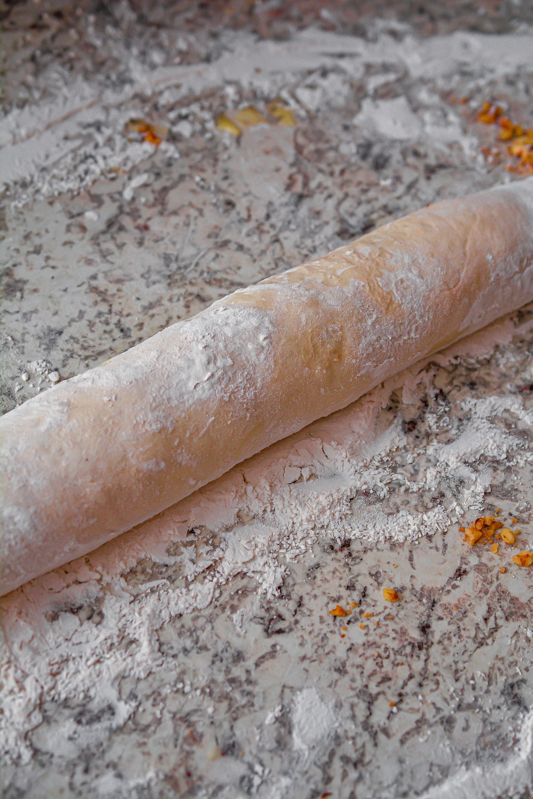 Roll the dough up tightly lengthwise, using the water to seal the dough closed.