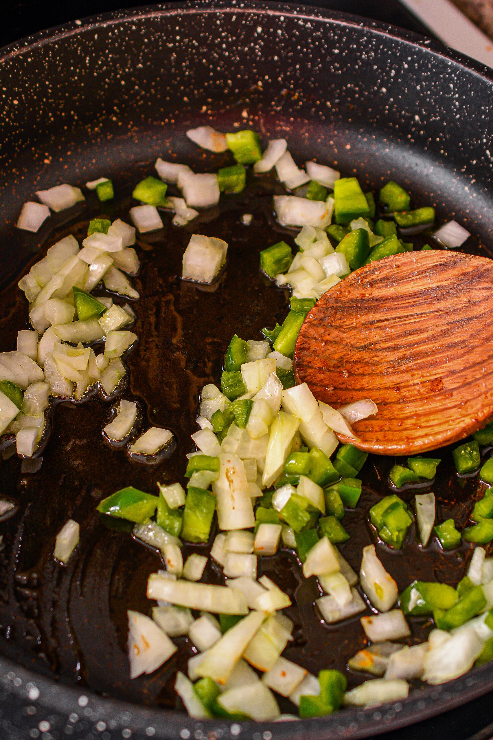 Saute the onions and peppers over medium heat until softened.