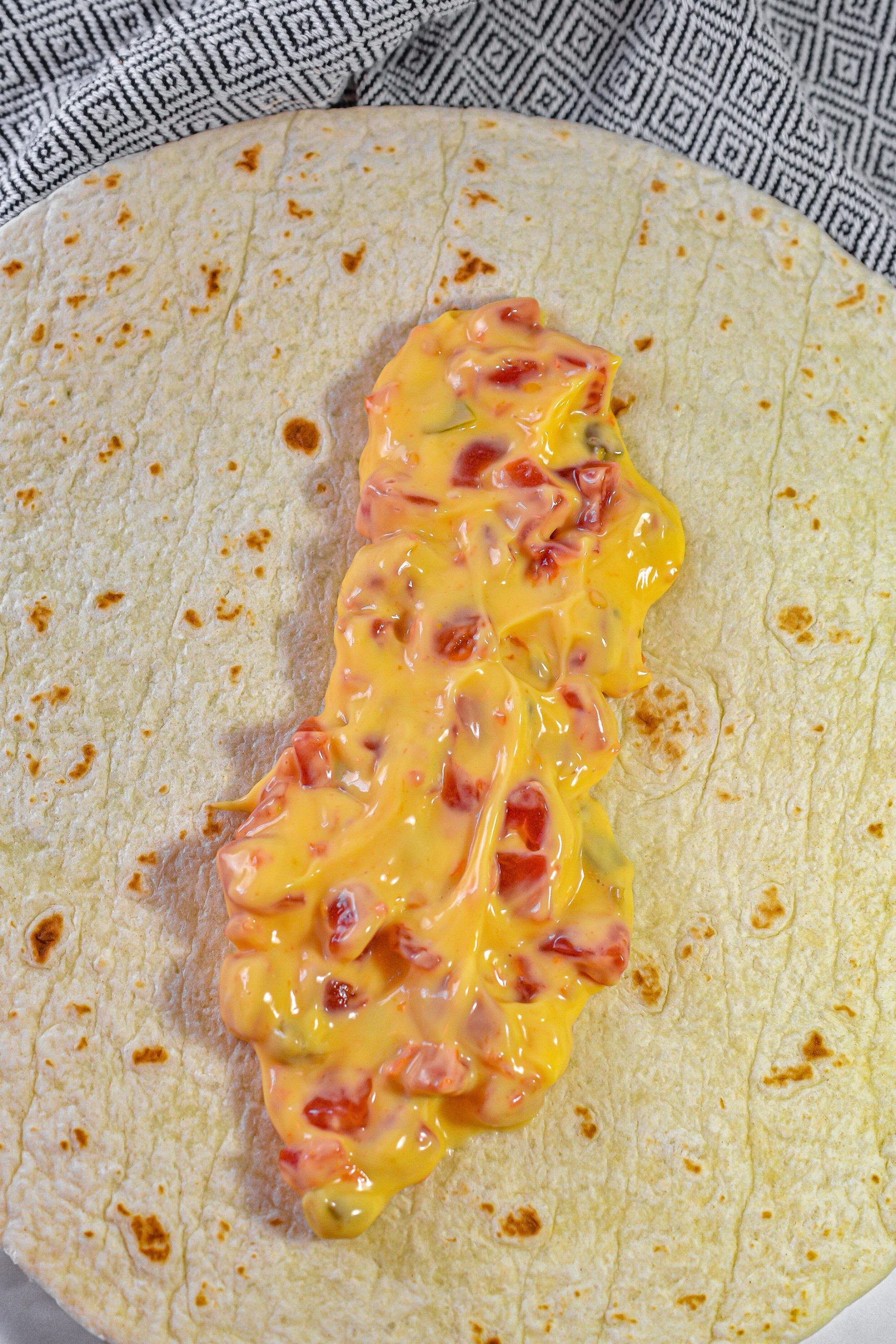 Place a layer of the nacho cheese mixture down the center of each tortilla.