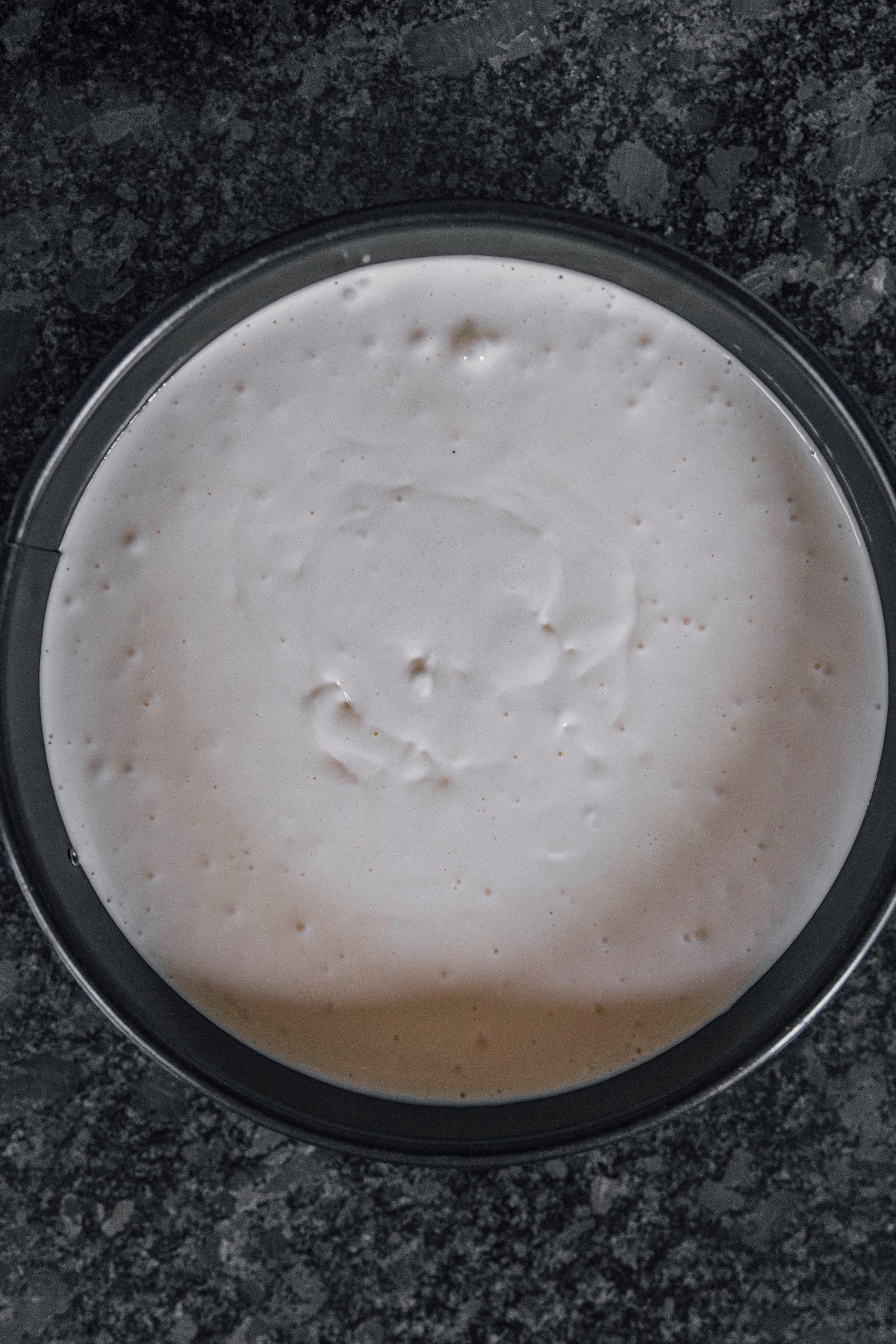  Pour the cheesecake mixture into the pan on top of the graham cracker base. 