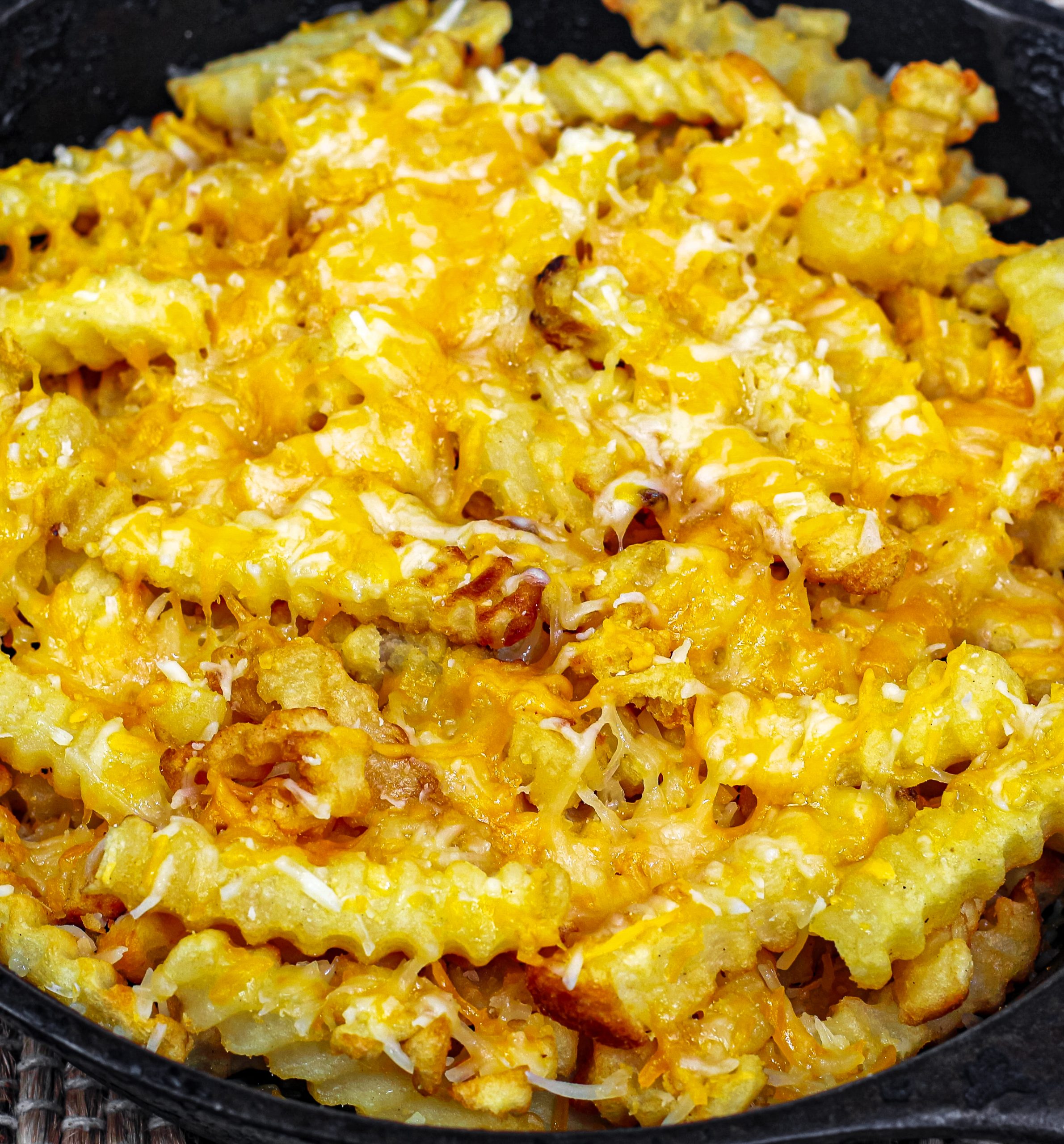 Using a castiron skillet, place the baked french fries, Mexican shredded cheese, and diced carne asada, then broil until the cheese is melted.