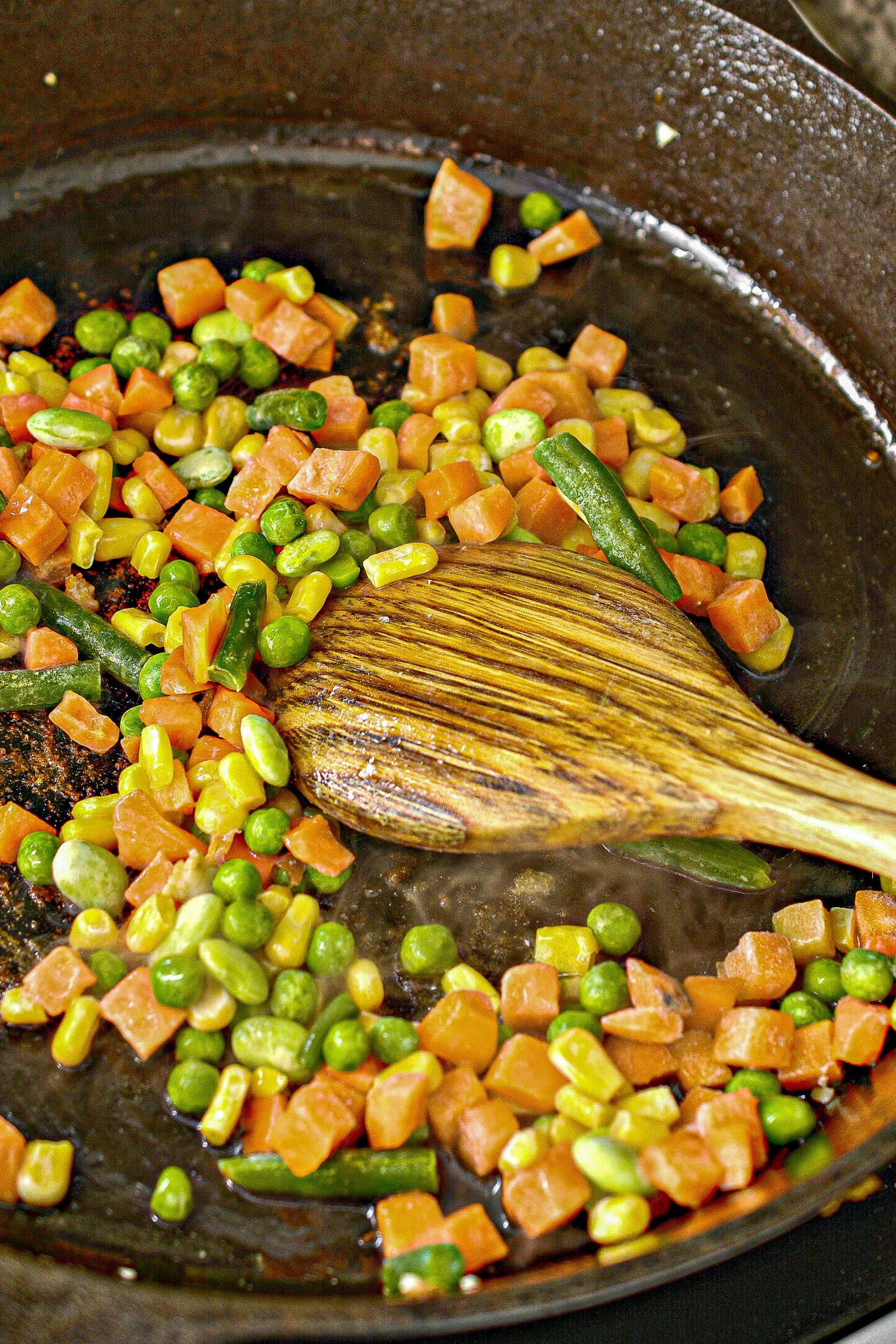 Add the veggies and garlic to the skillet and cook until the vegetables begin to soften.