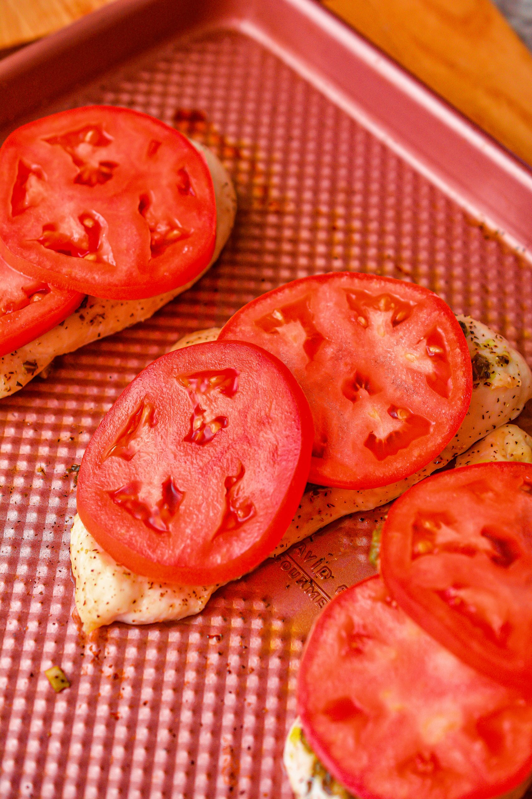 Top the chicken pieces with slices of tomato.