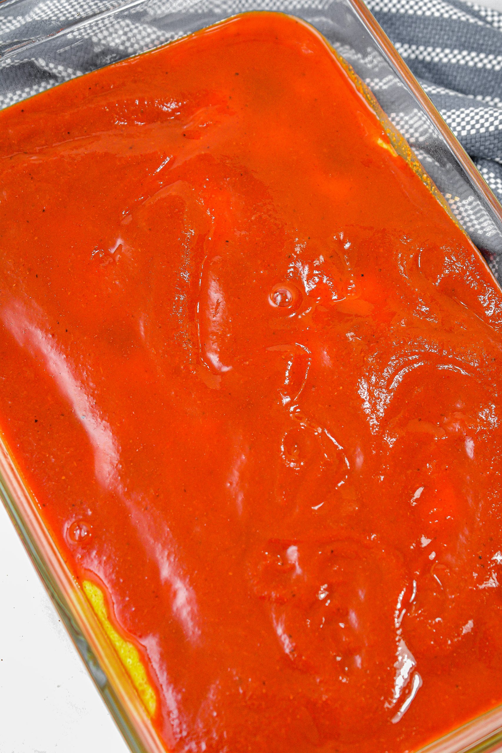 Spread the enchilada sauce over the top of the cornbread.