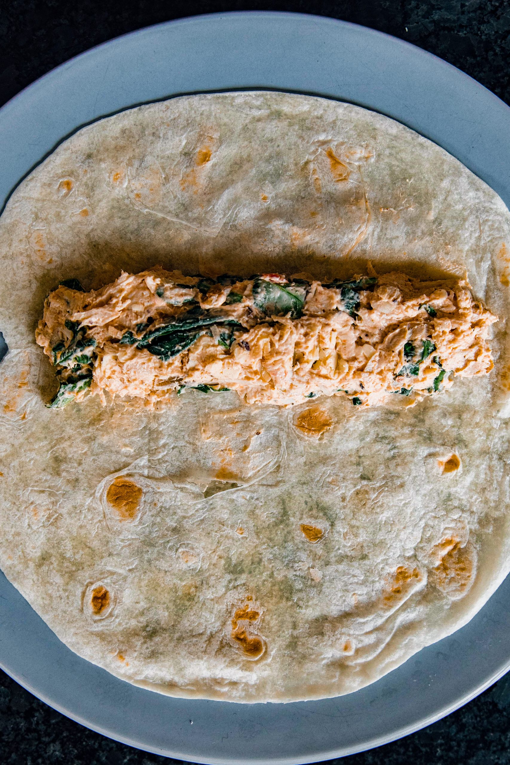 In the middle of each tortilla, place a spoonful of filling in a line and roll tightly. 