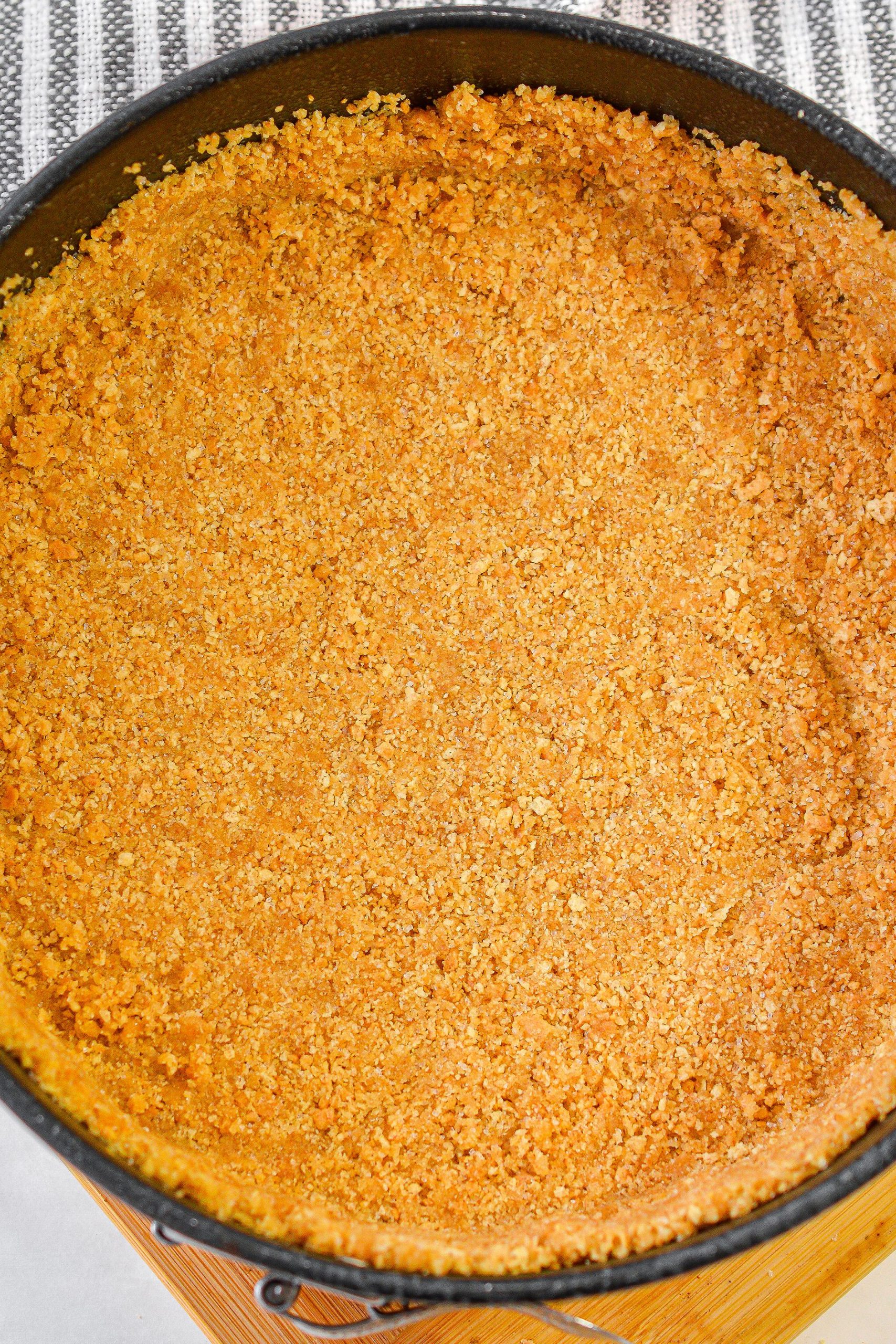 In a bowl, combine the graham cracker crumbs, 2 Tbsp sugar and melted butter. 