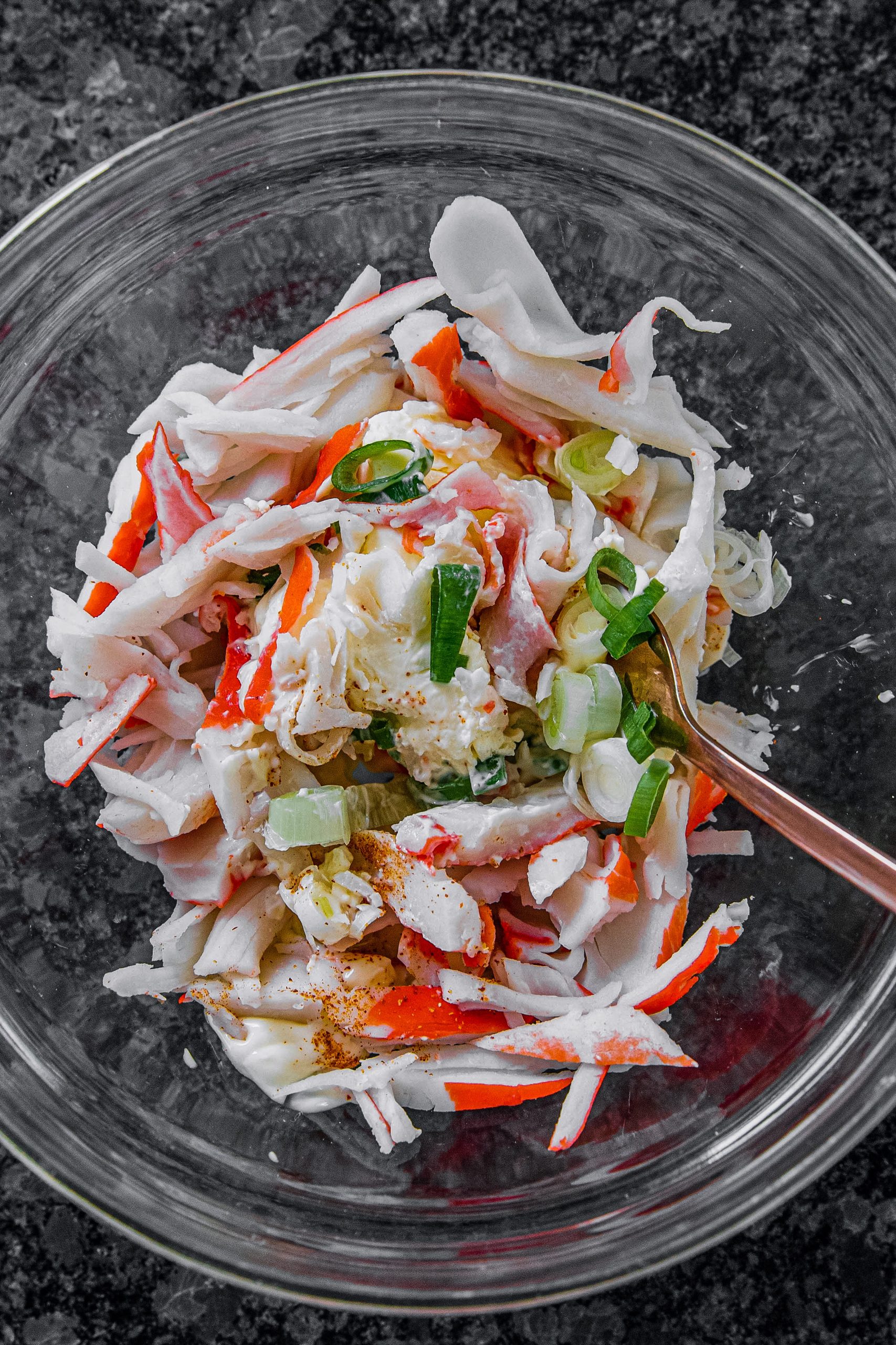 Mix the cream cheese, mayonnaise, and crabmeat in a bowl. Add the onion and the red pepper.