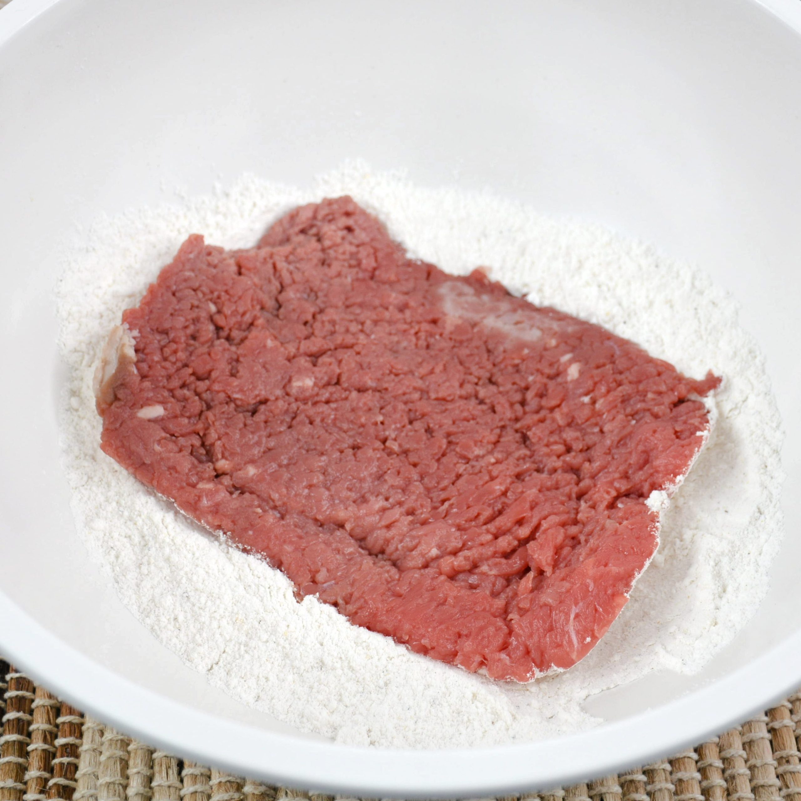 Dredge both sides of cubed steak in a flour mixture.