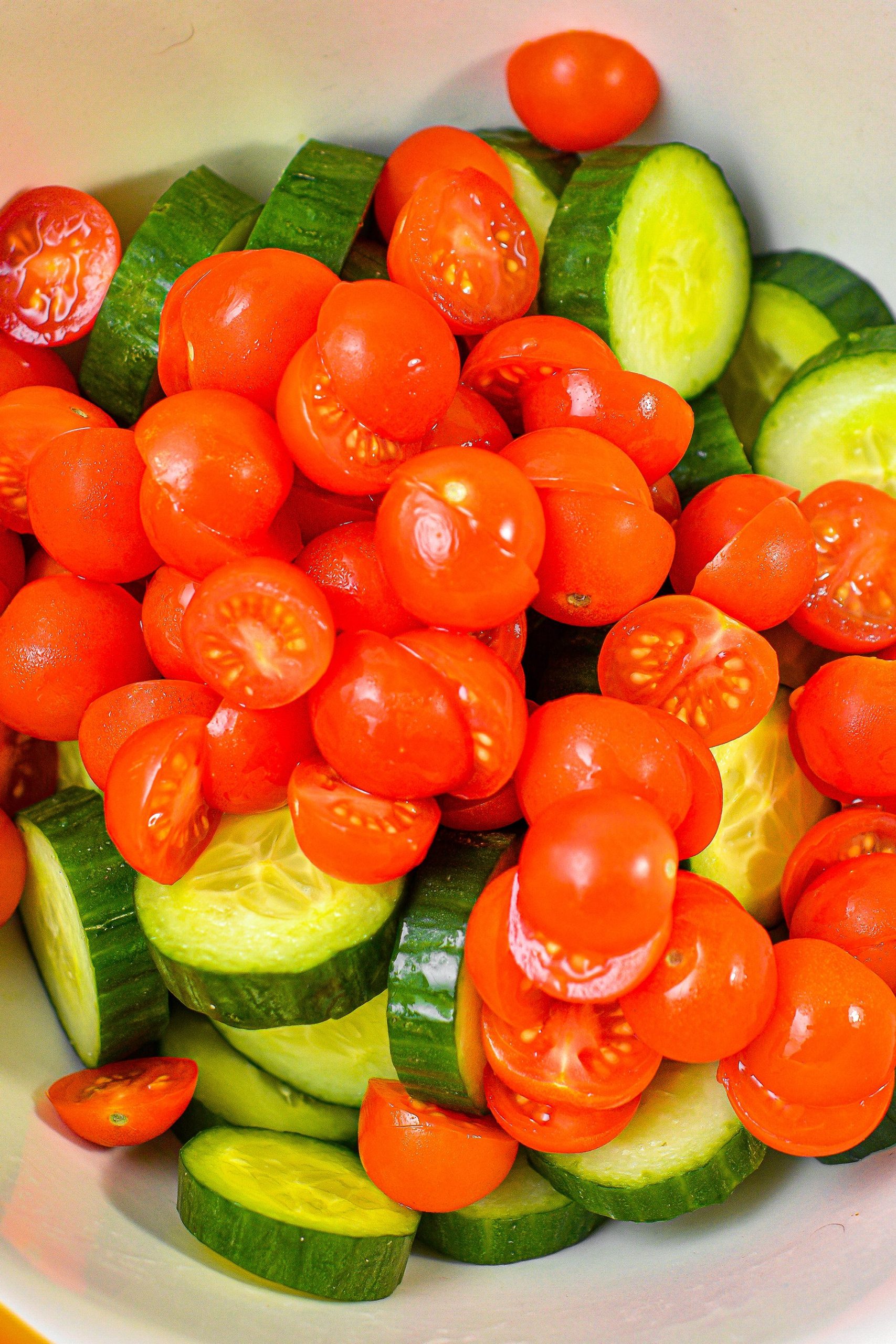 In a large bowl, toss together the cucumbers, tomatoes and onions.