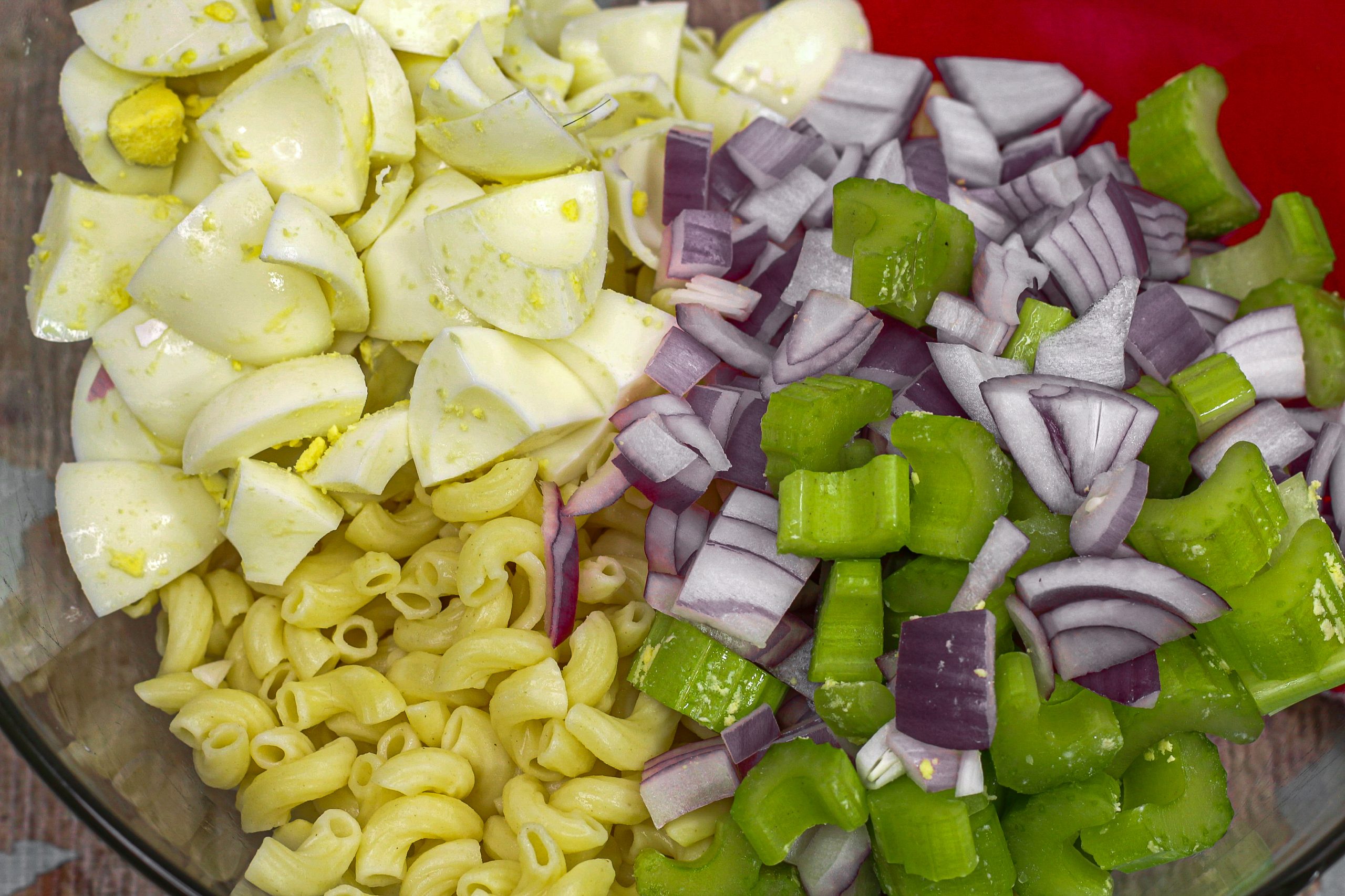 Add the chopped onion and celery to the pasta bowl.