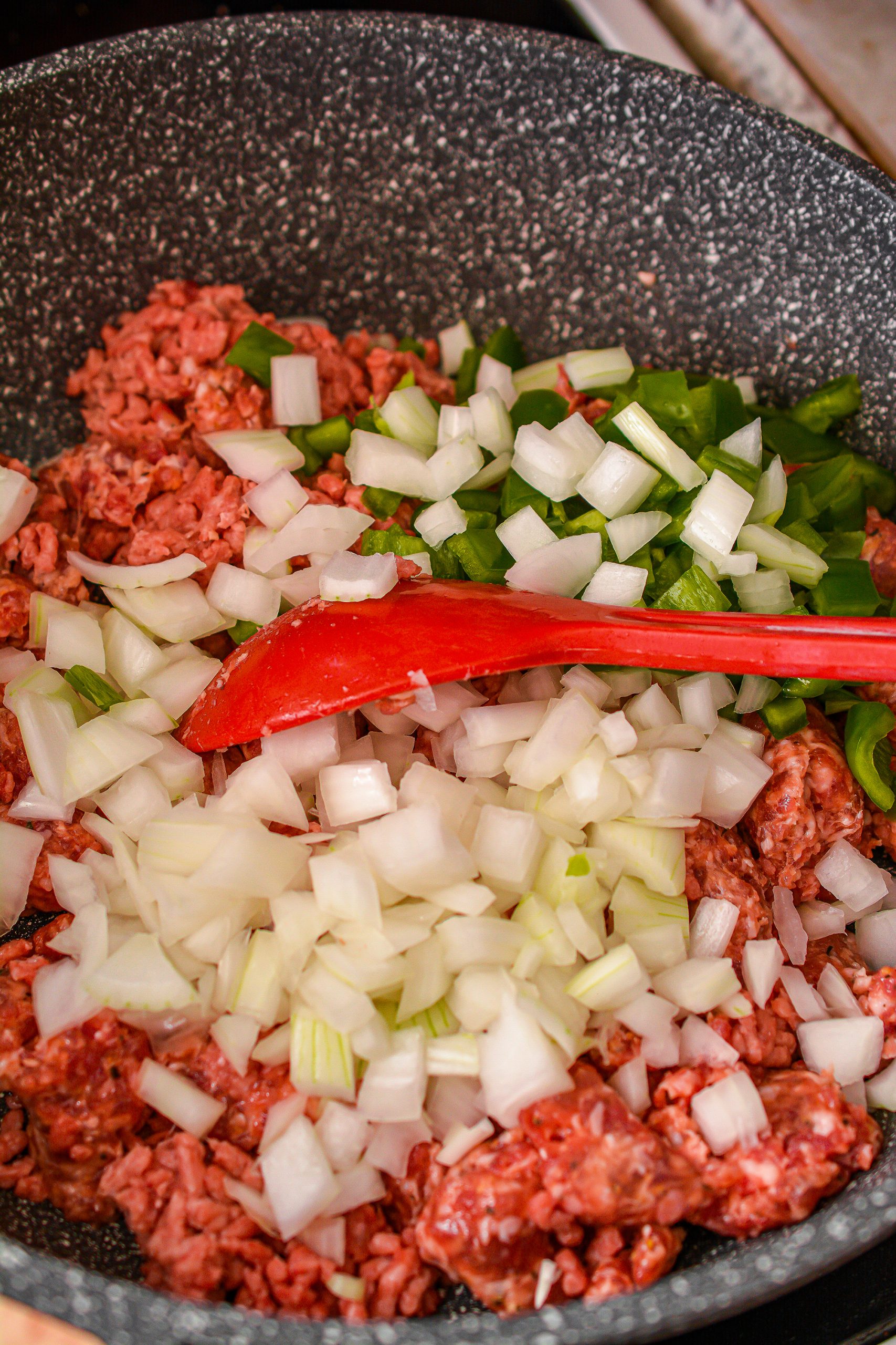 Cook the meat and vegetables over medium-high heat in a large skillet until the meat is browned completely, and the vegetables have begun to soften. 