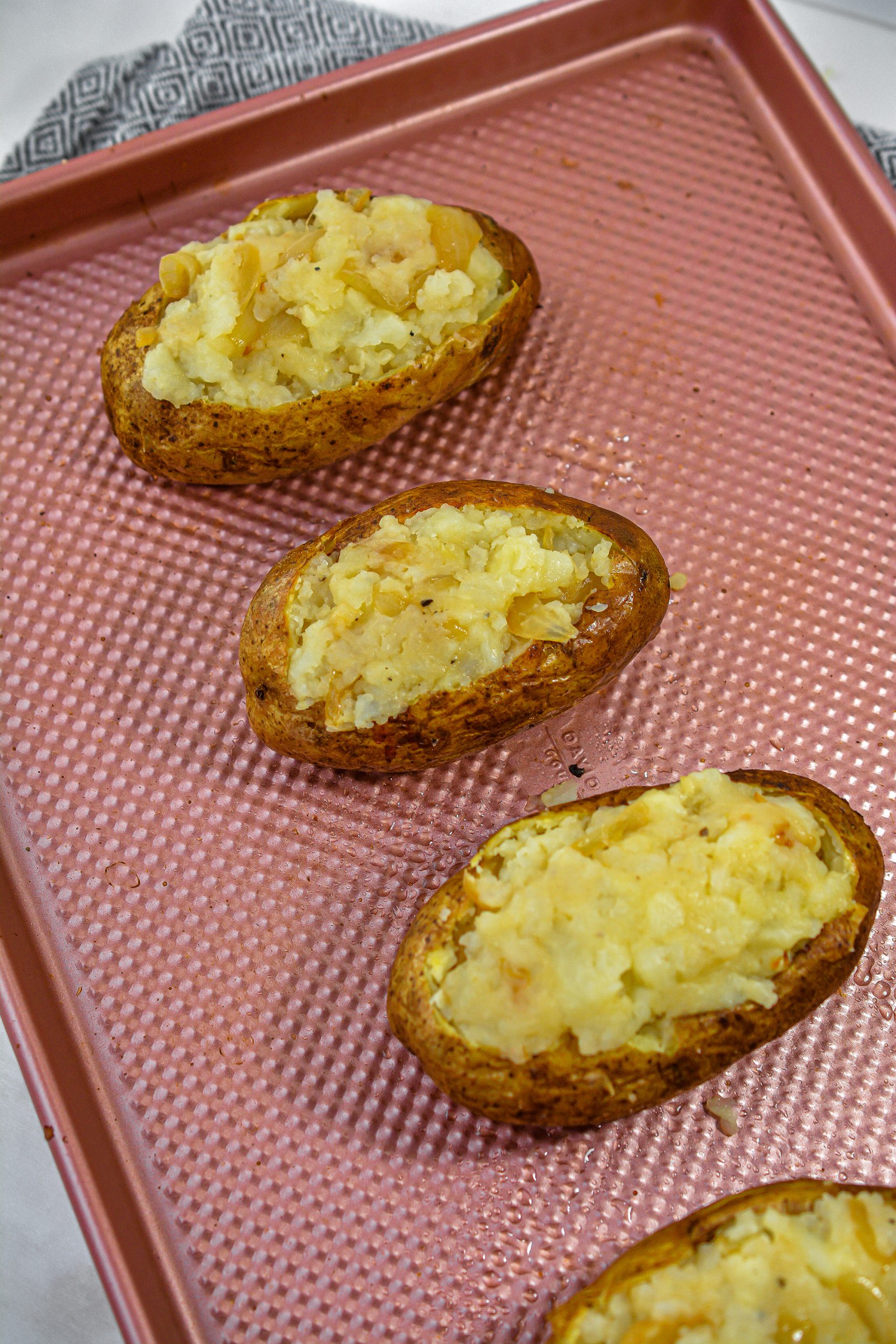 Stuff the potatoes with the filling and top with the remaining onion mixture and shredded cheese.