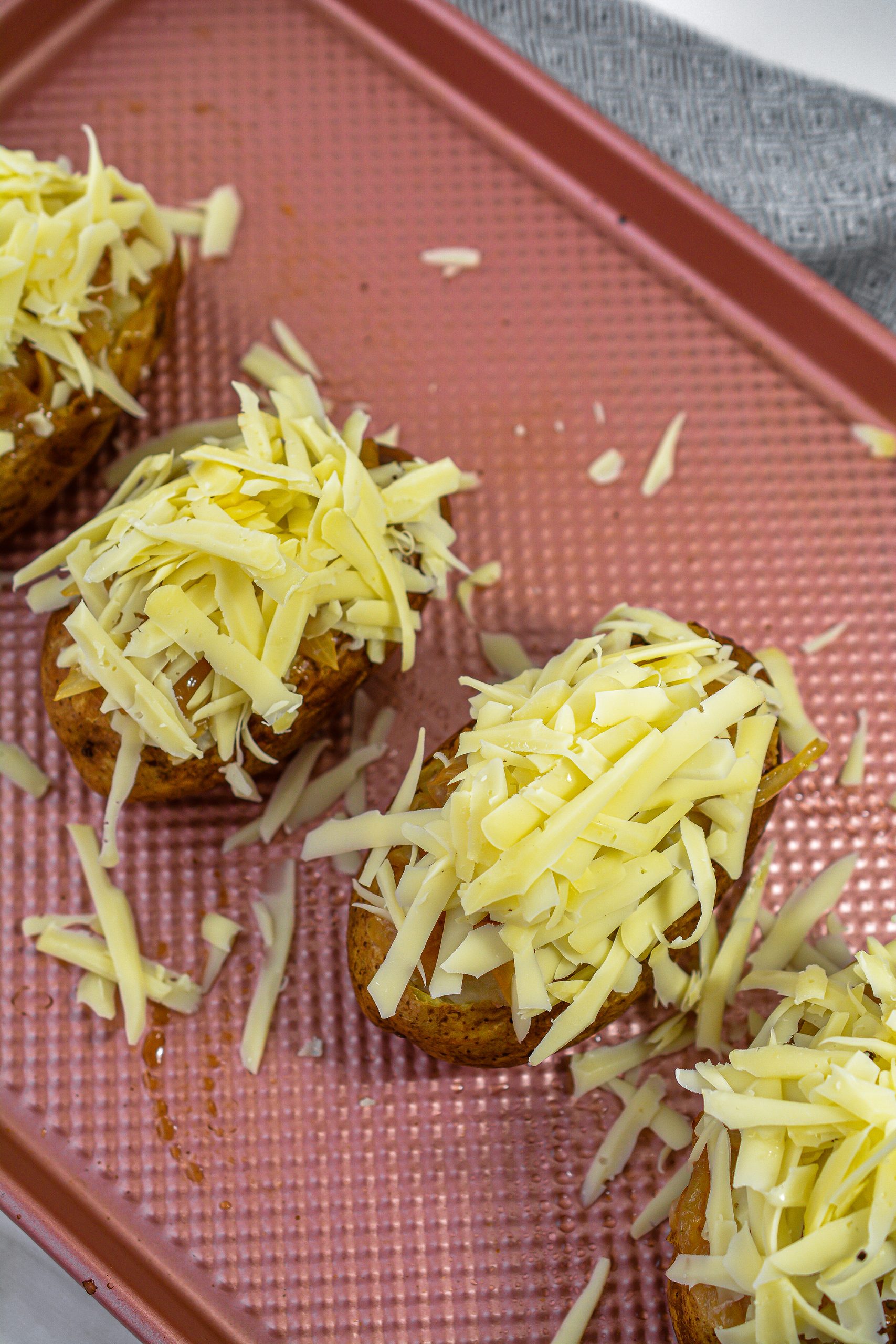 Stuff the potatoes with the filling and top with the remaining onion mixture and shredded cheese.