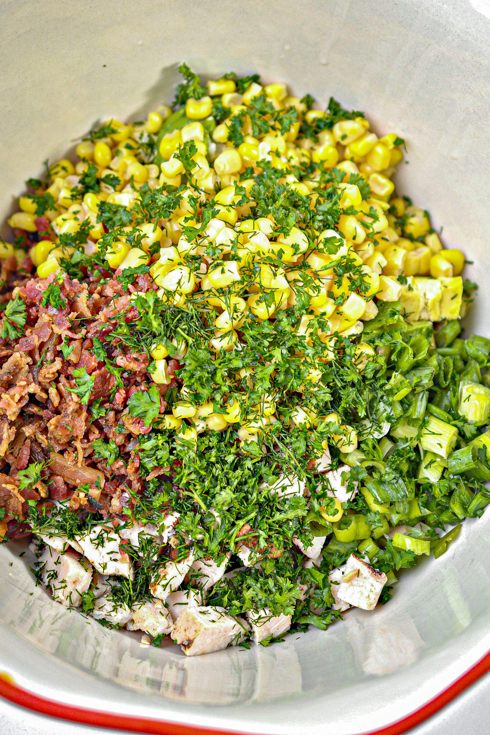 In a large mixing bowl, combine the chicken, chopped avocado, corn, green onion, bacon crumbles, dill and parsley.