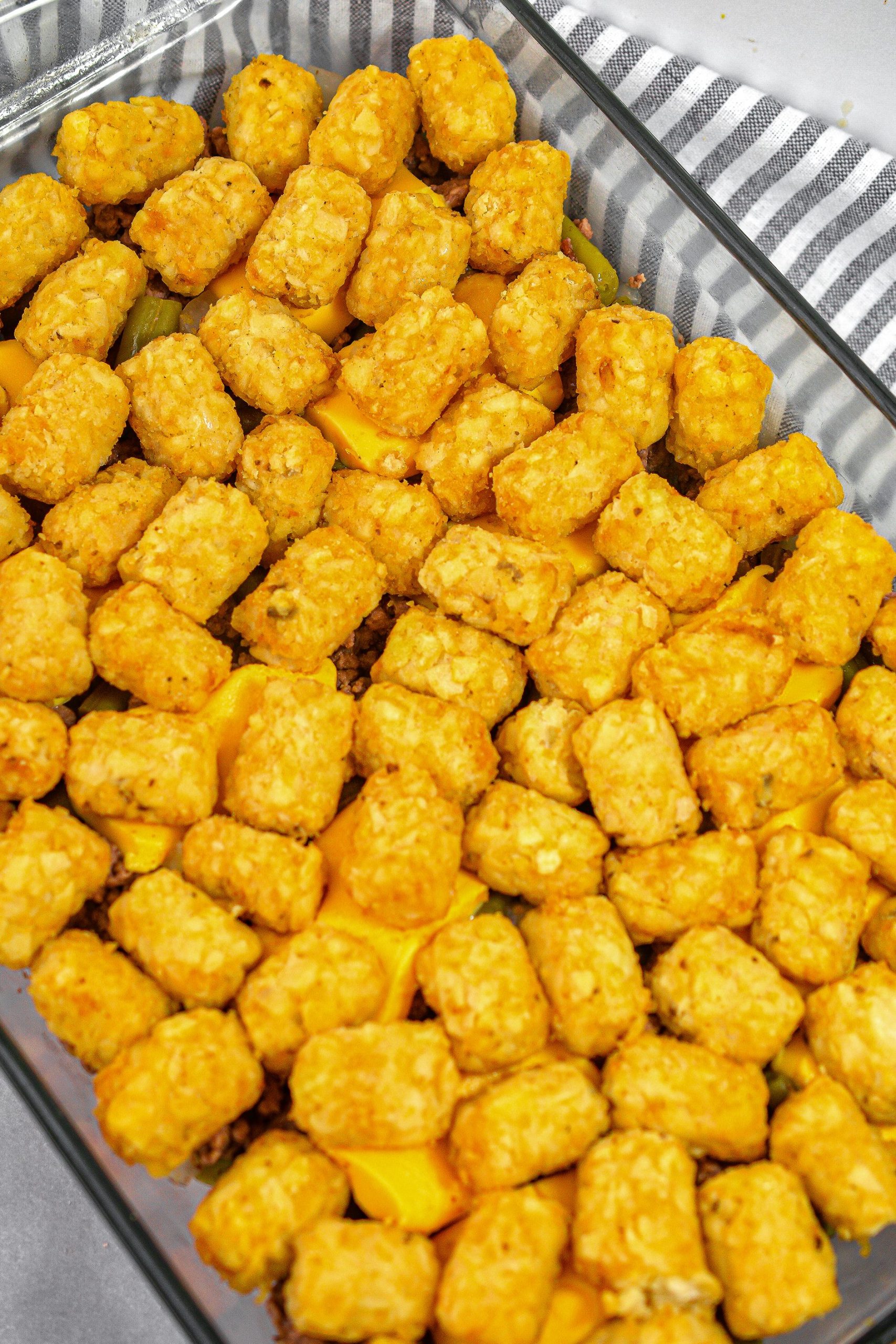 Place a layer of tater tots on top of the mixture.