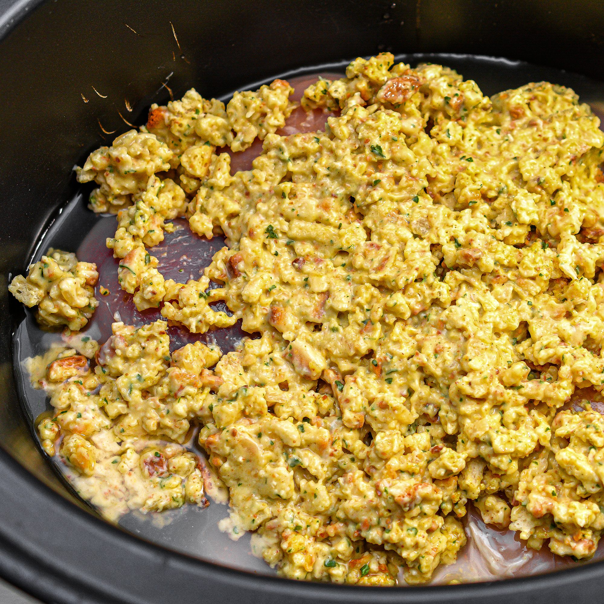 Spread the stuffing mixture over the chicken in the slow cooker.