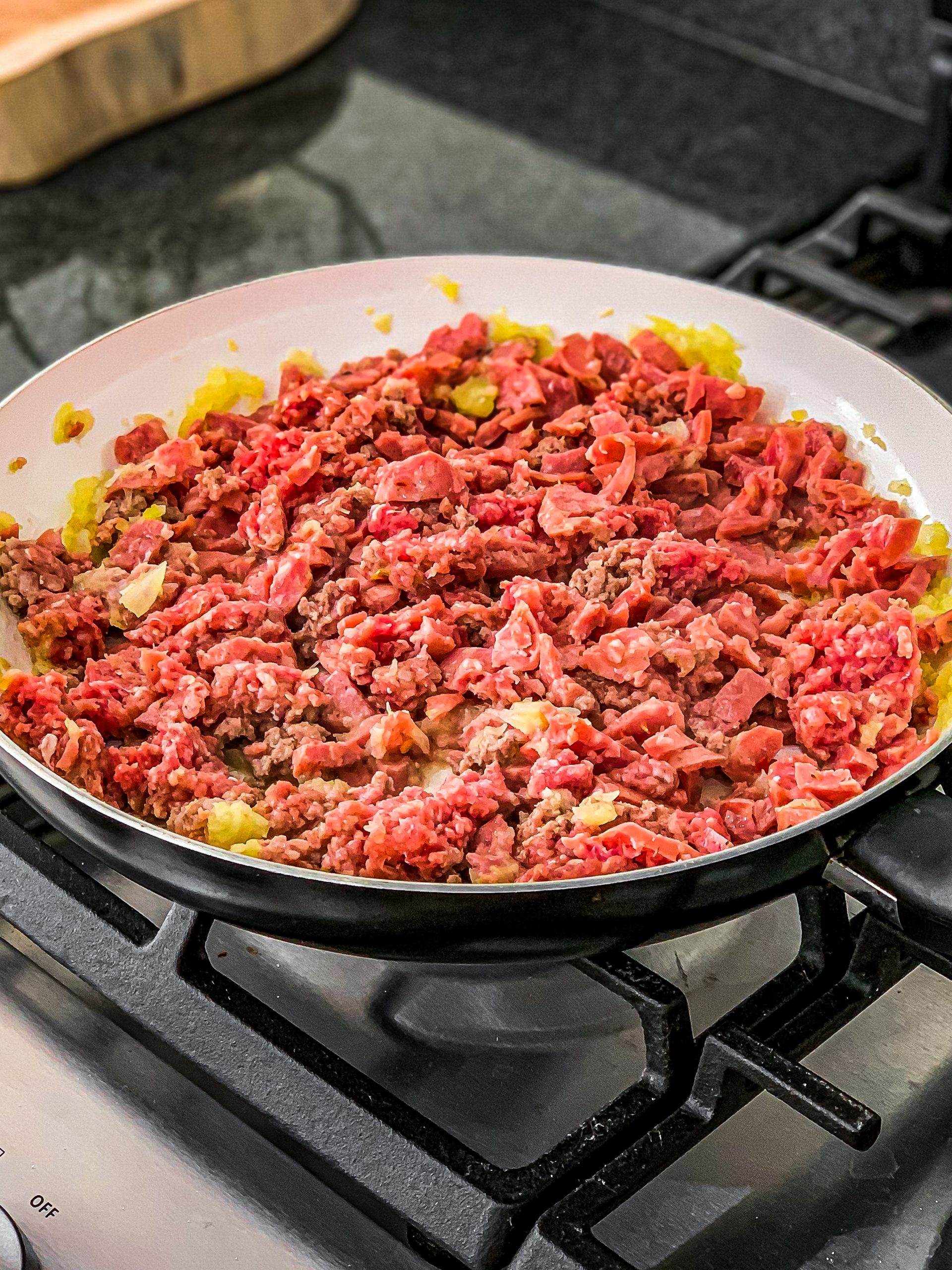 Add the ground beef along with the sausage, and cook until golden brown.