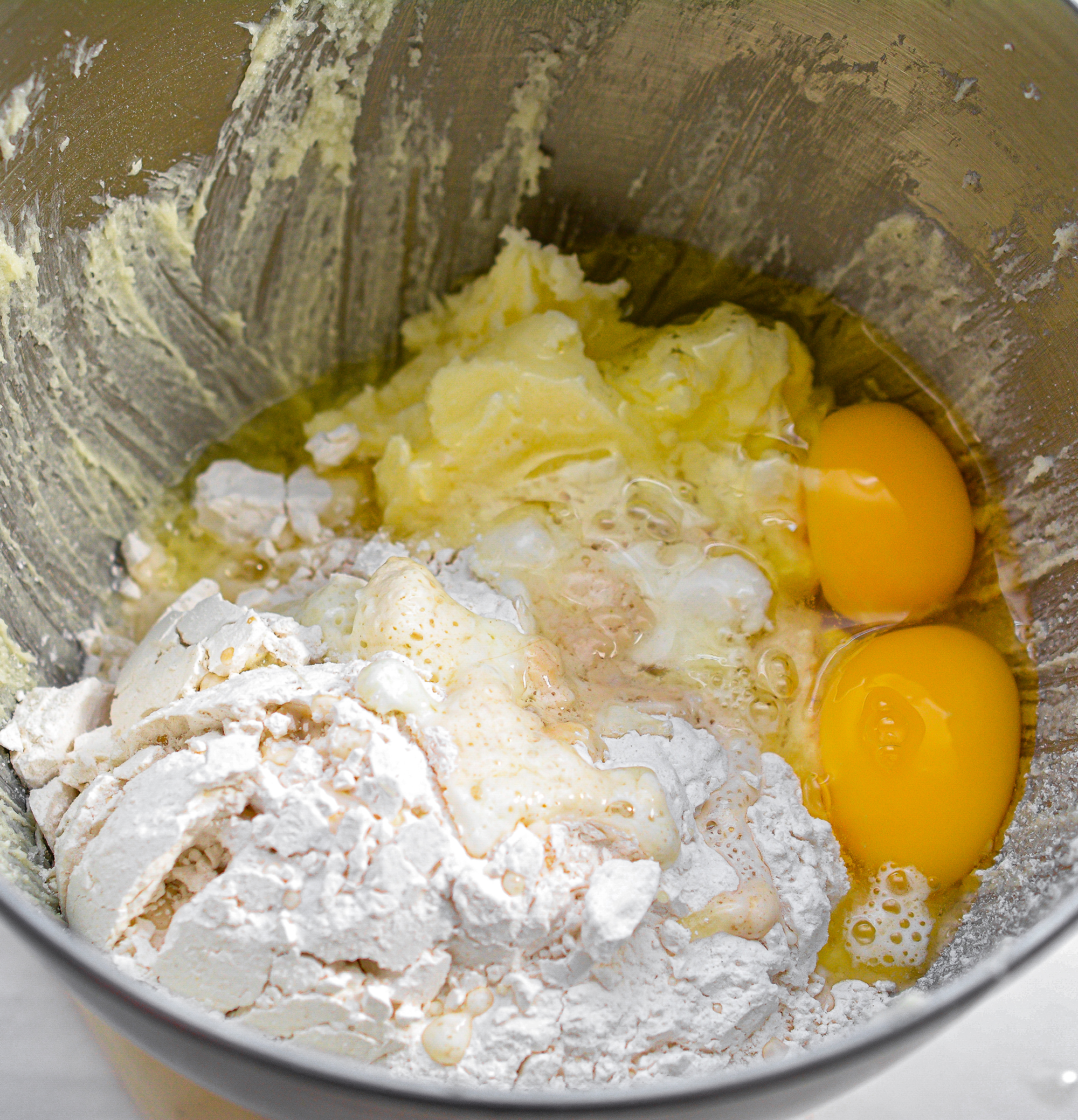 Mix in the flour, baking powder, eggs, lemon juice, and 1 tsp vanilla. Beat on high until well combined.