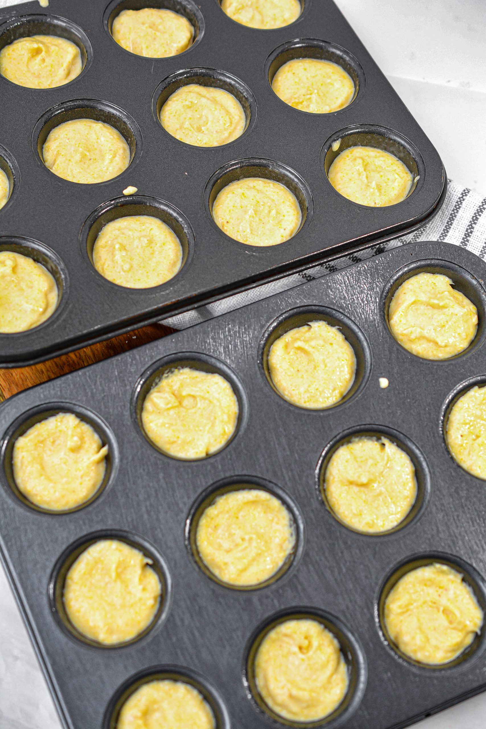  Spoon the batter into the sections of well greased mini muffin tins, filling them about ¾ of the way full.
