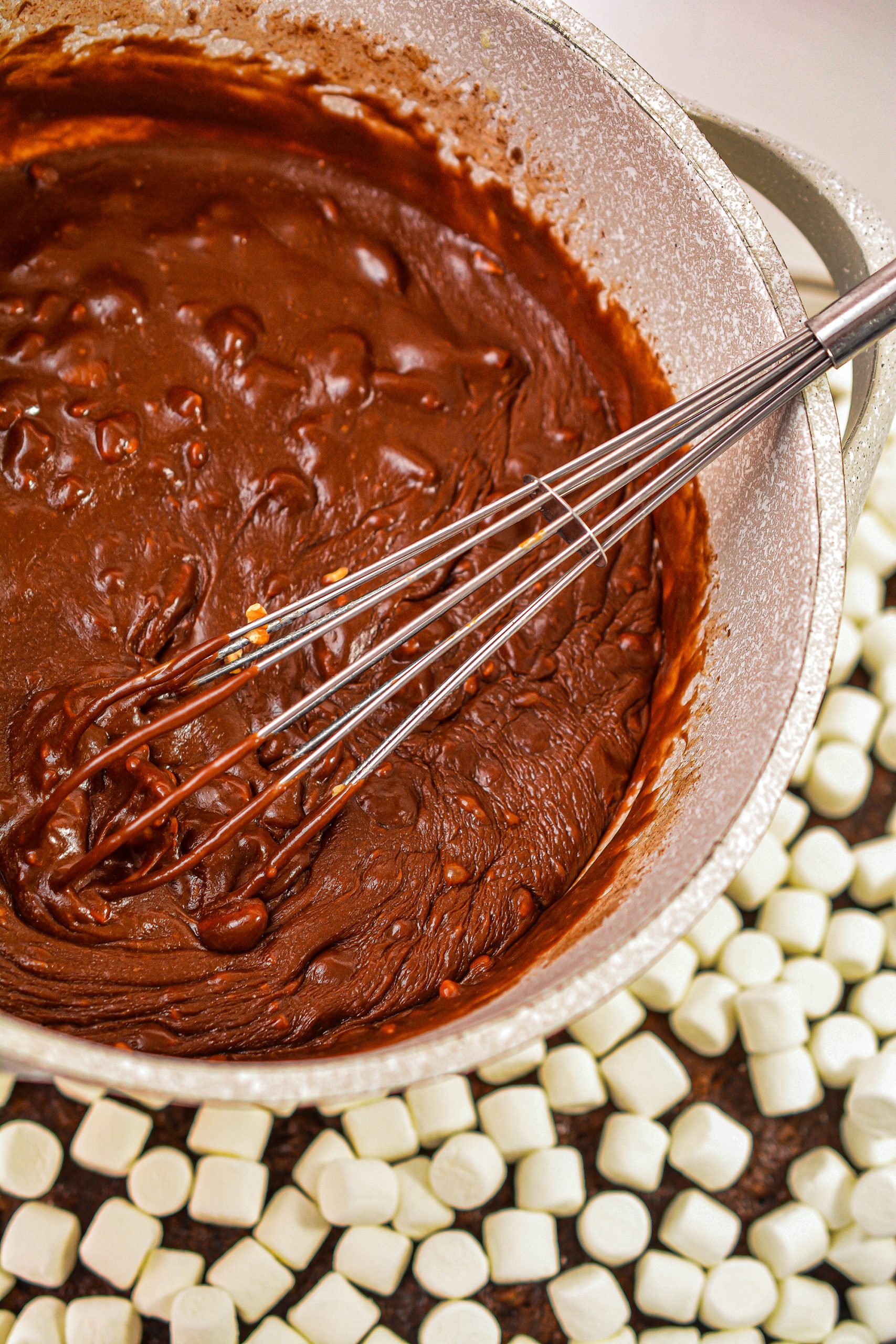 Drizzle the chocolate mixture over the mini marshmallows on the cake.