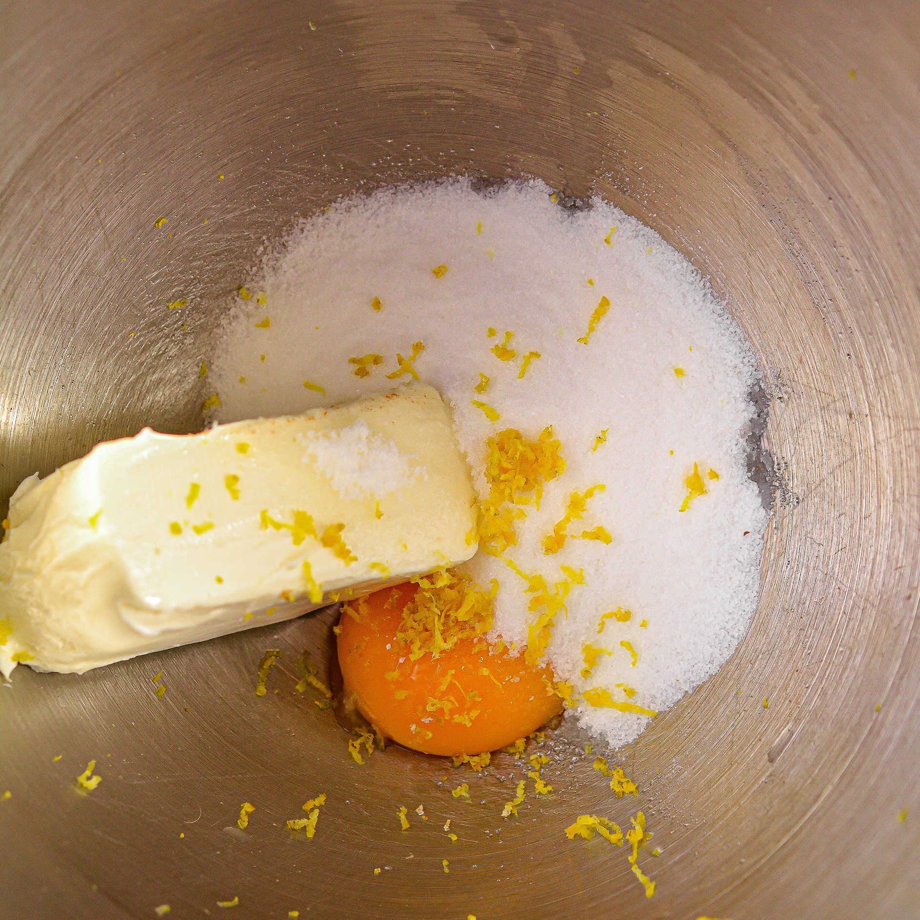 In a mixing bowl, beat together the cream cheese, granulated sugar, lemon zest, vanilla extract and egg yolk until smooth and creamy.
