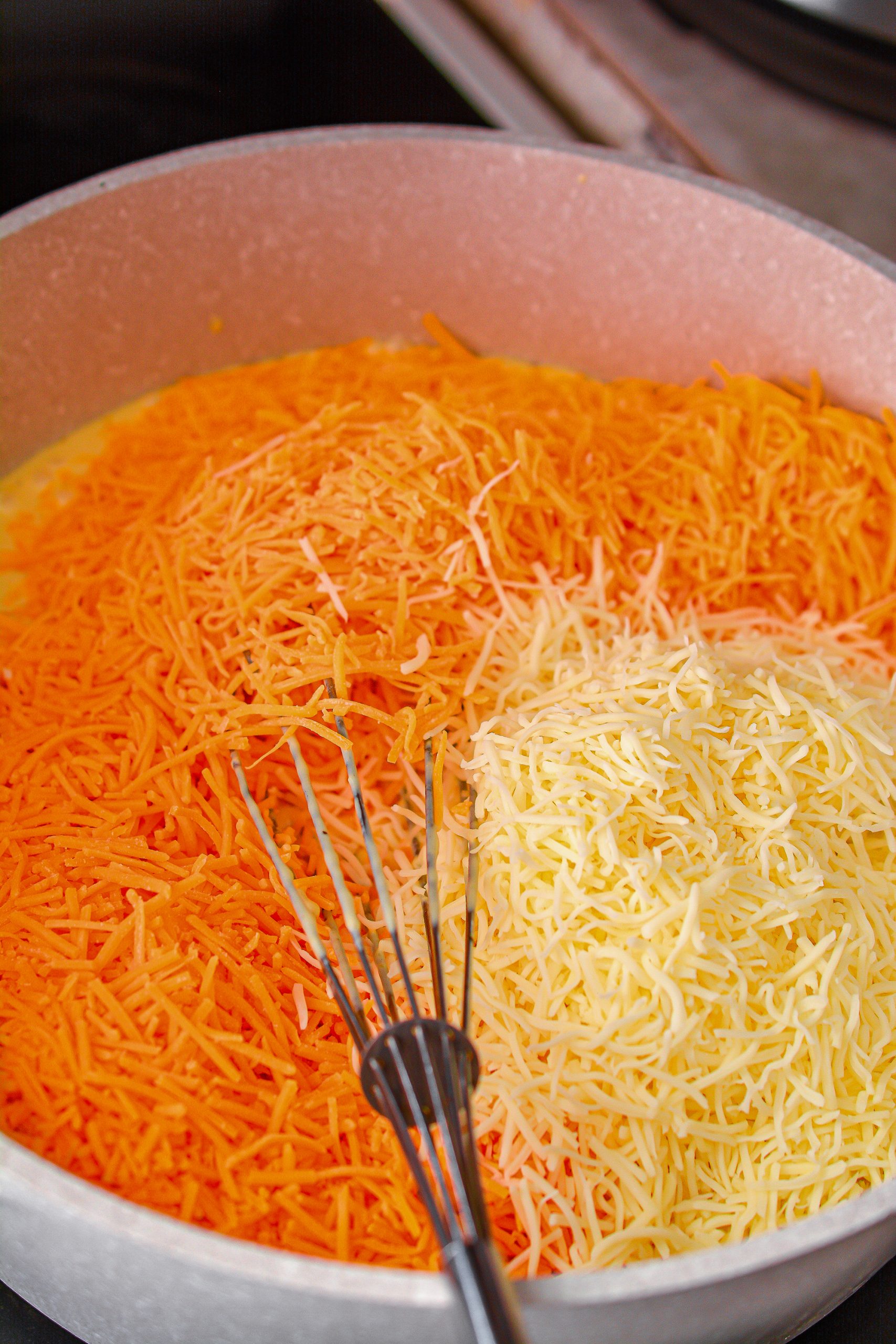 Place the shredded cheeses into the saucepan, and stir to combine until the cheeses have completely melted.
