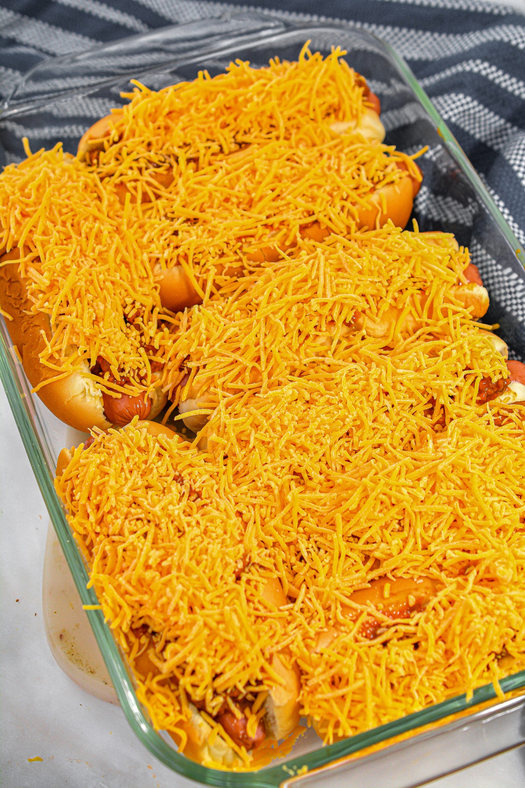 Pile the cheese on top of the hot dogs.